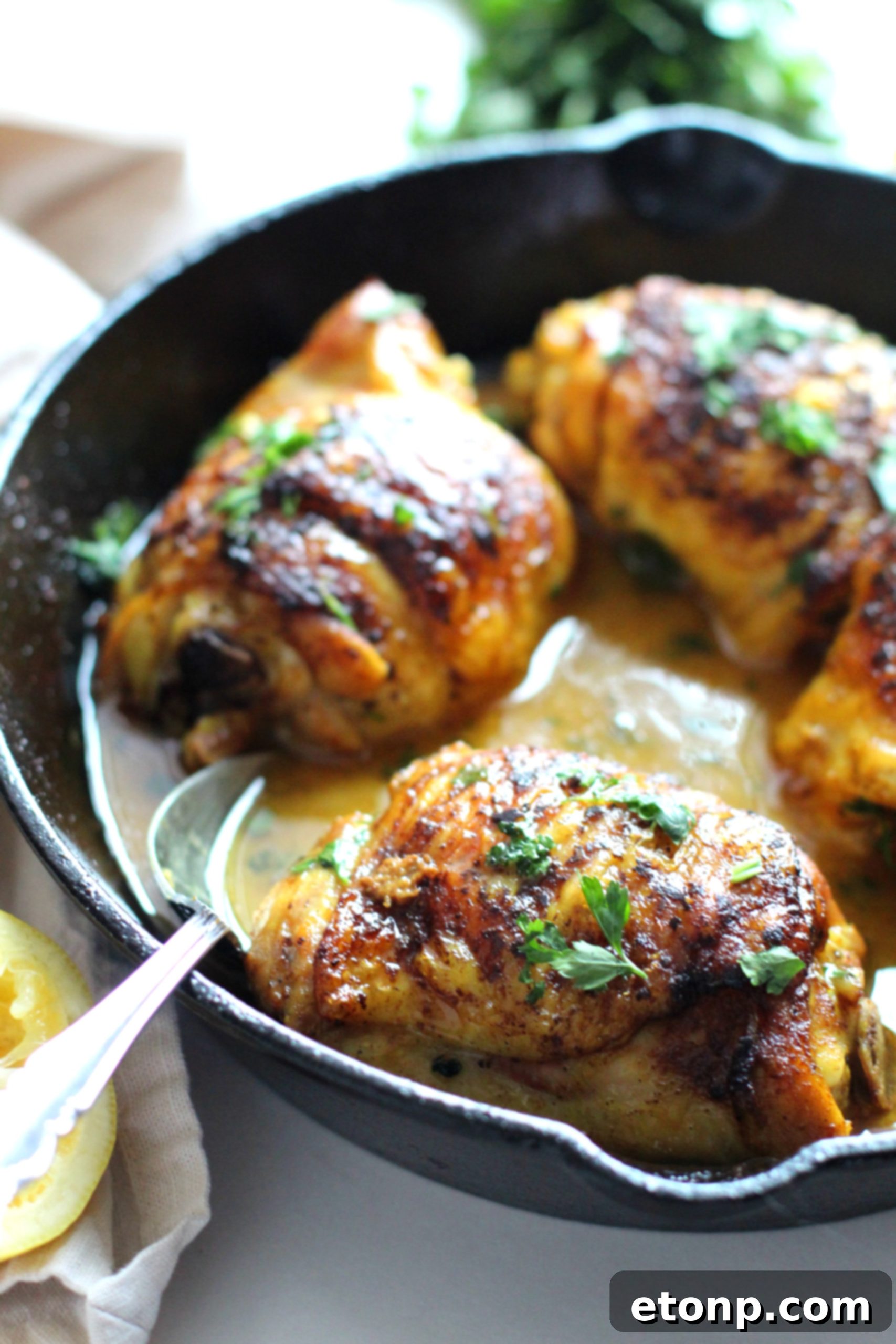 Sticky Sweet Lemon Chicken Skillet 2 Golden-brown brown sugar lemon chicken thighs sizzling in a cast iron skillet, garnished with fresh parsley.