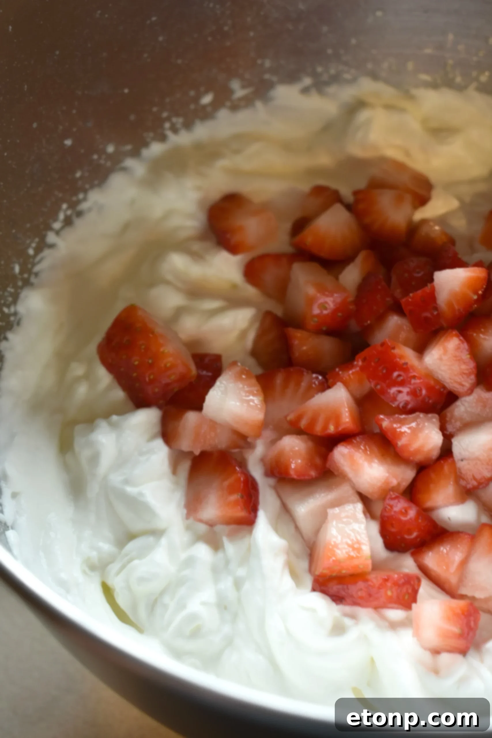 A slice of Strawberry Creamsicle Layered Cake, showing the moist strawberry cake layers and the thick, creamy frosting.