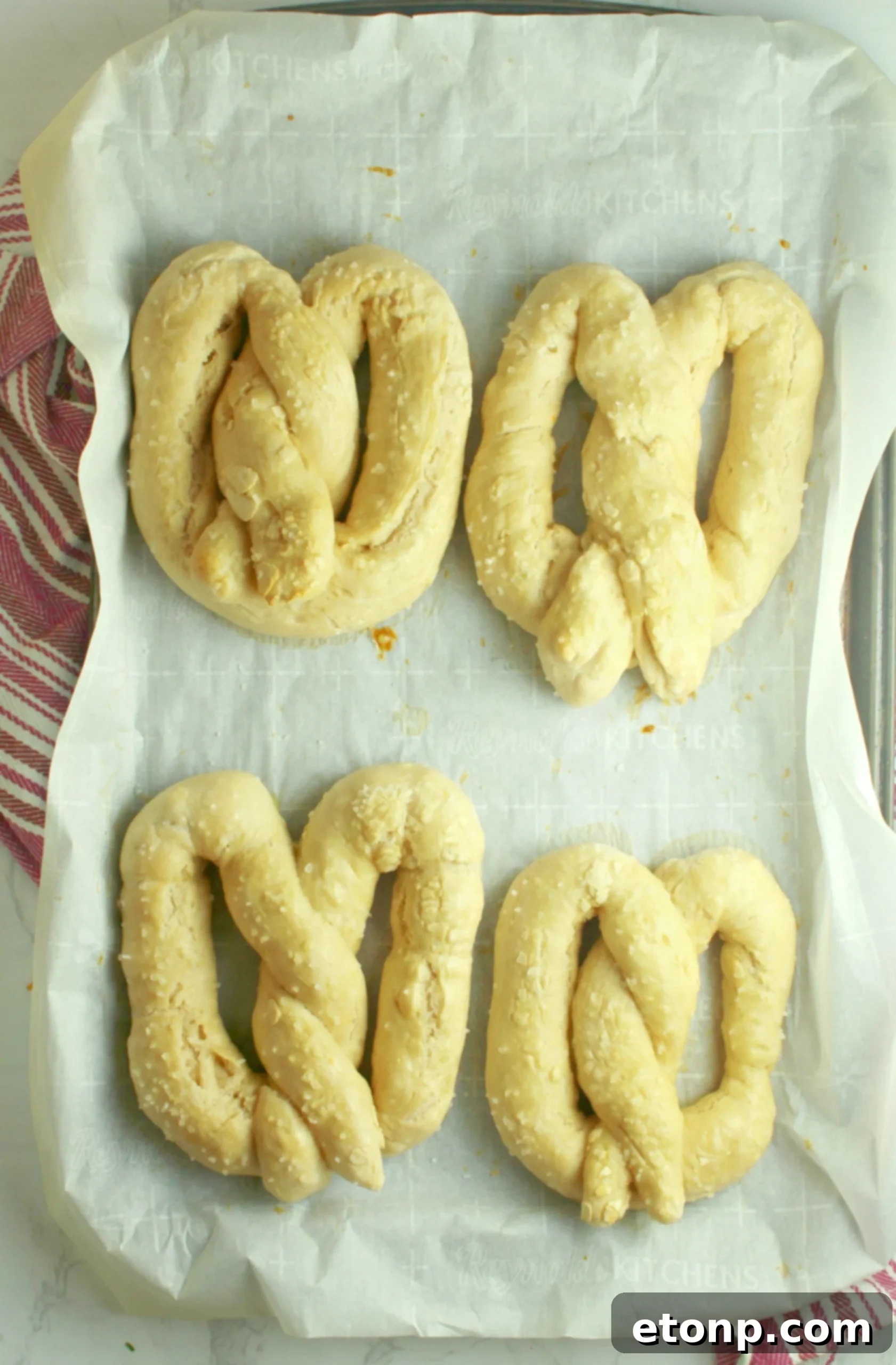 A close-up shot of golden soft pretzels arranged on a wooden board, showcasing their beautiful texture.