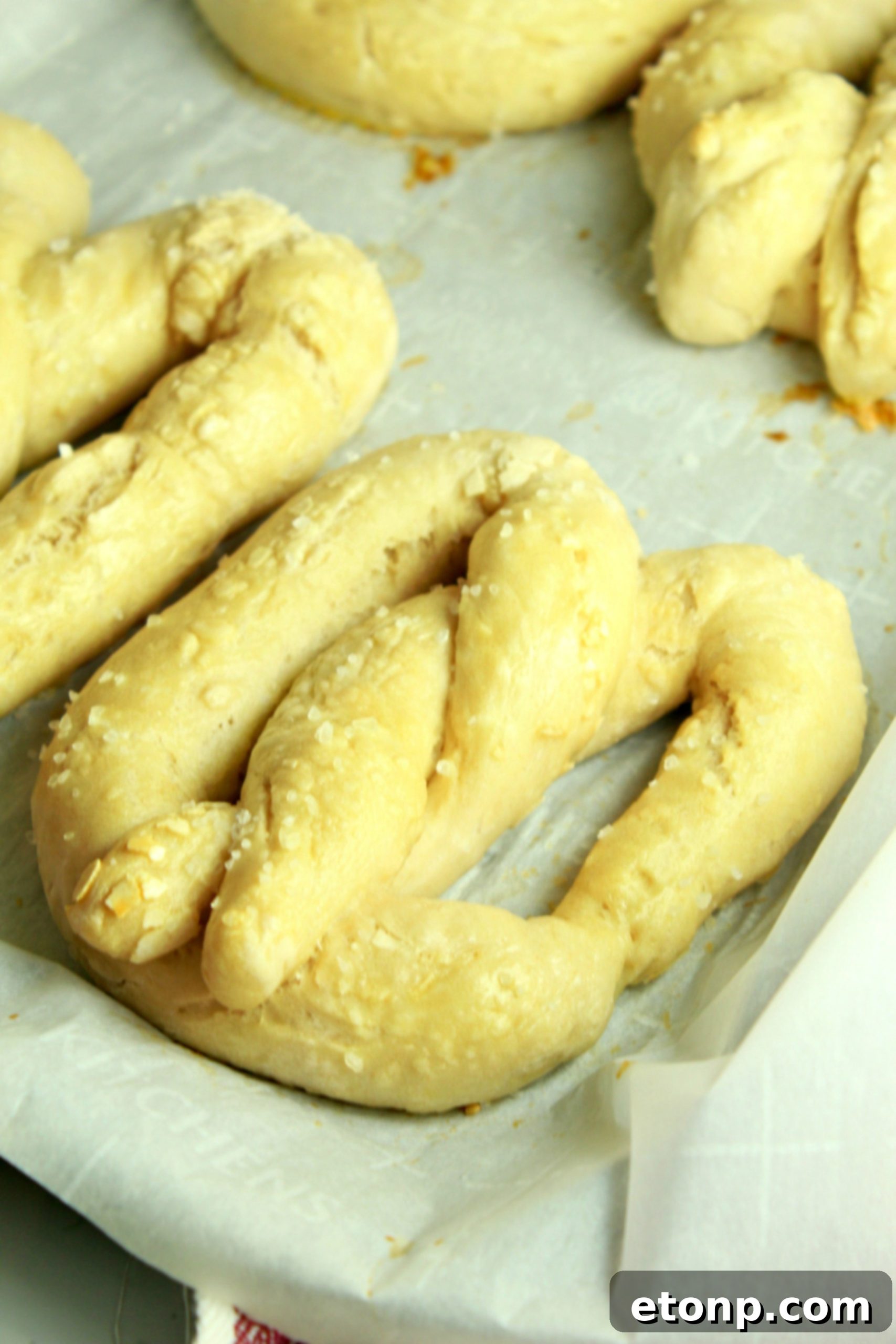 Platter of soft pretzels served with a selection of dipping sauces, including mustard and a creamy dip.