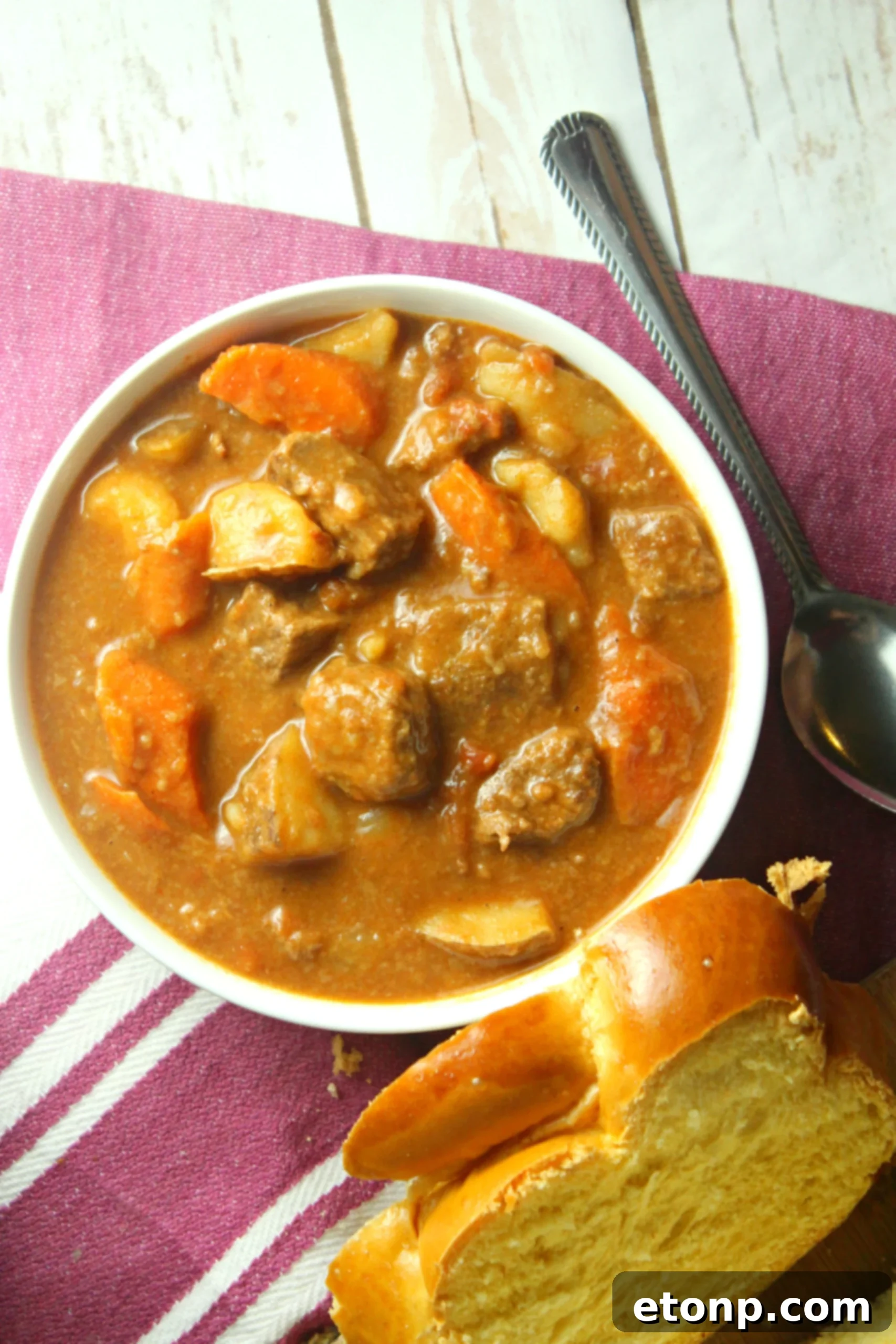 A vibrant bowl of traditional Hungarian Goulash, brimming with tender beef, colorful vegetables, and a rich paprika-infused sauce.
