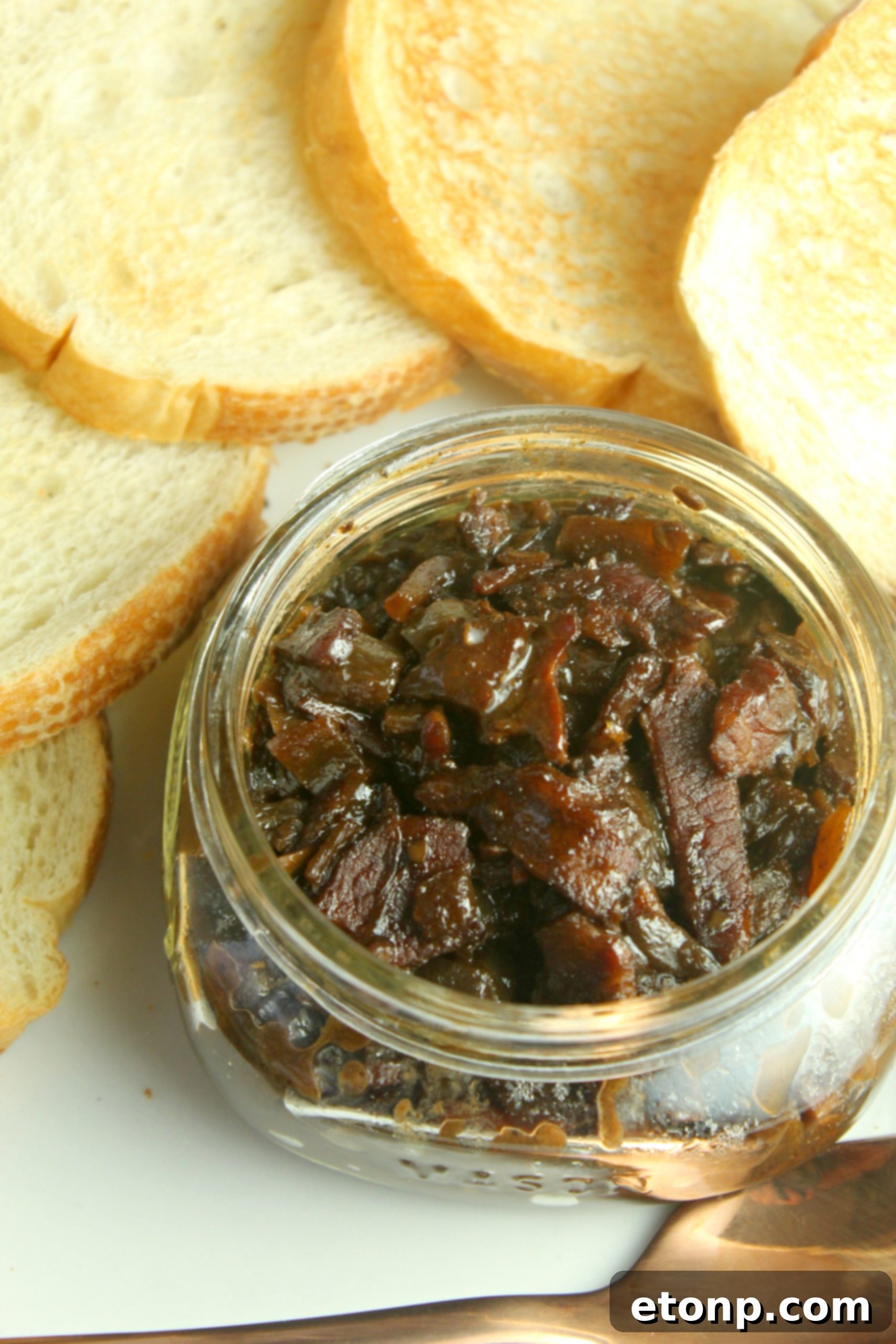 Delicious, rich bacon jam bubbling in a skillet as it slowly thickens and caramelizes