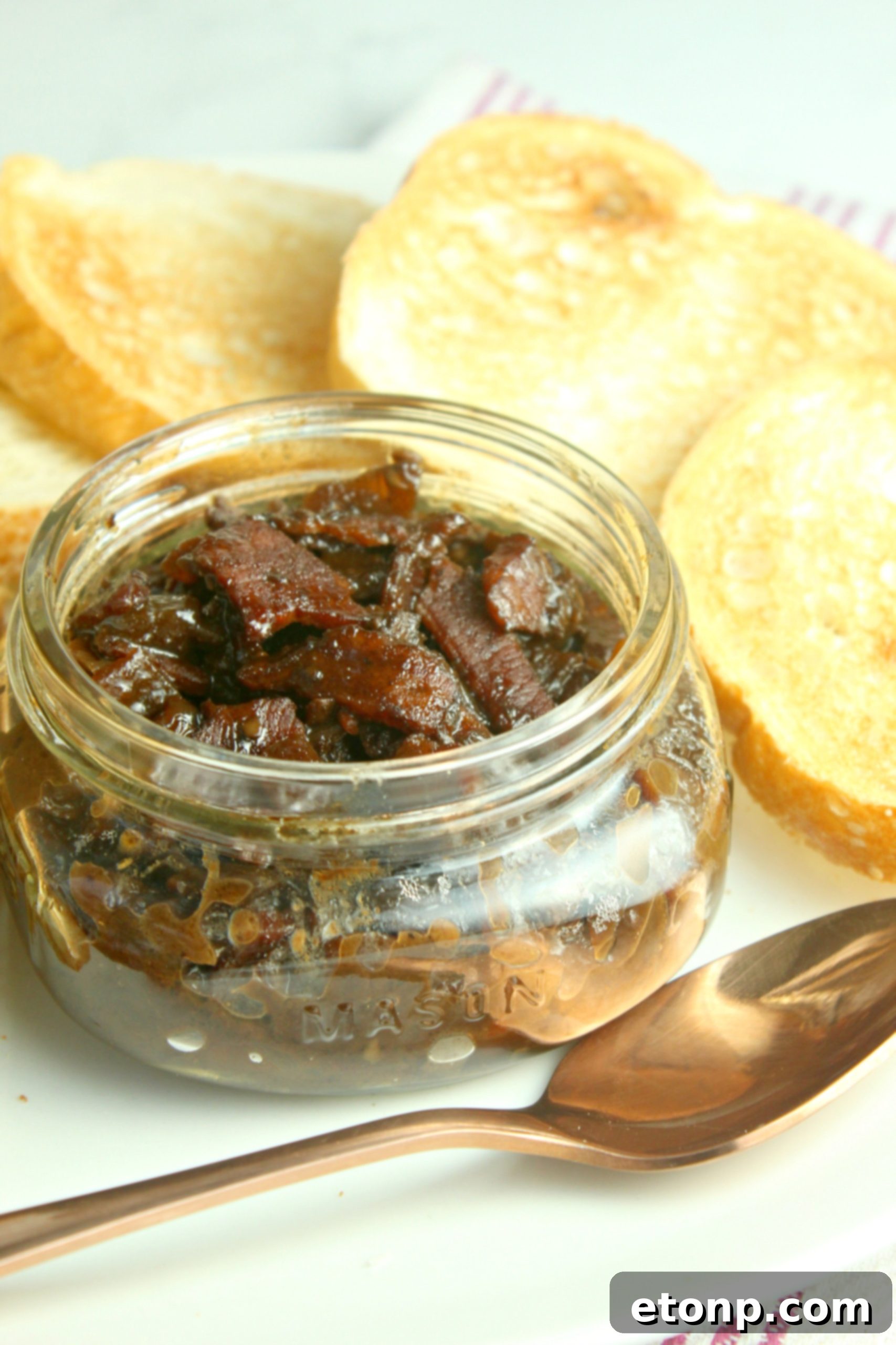 Assortment of glass mason jars filled with freshly prepared homemade bacon jam, ready for gifting