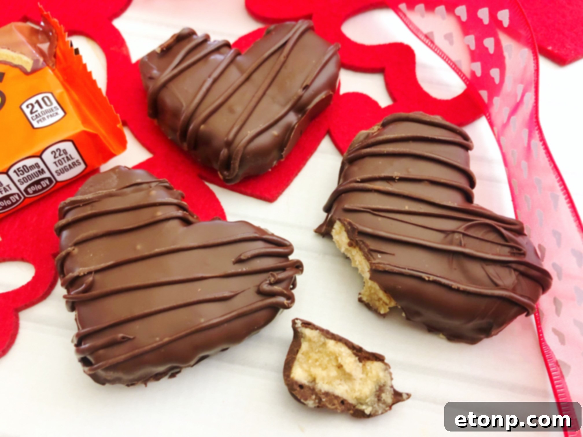 A close-up shot of a finished Reese's Peanut Butter Heart, beautifully drizzled with contrasting chocolate, resting on parchment paper.