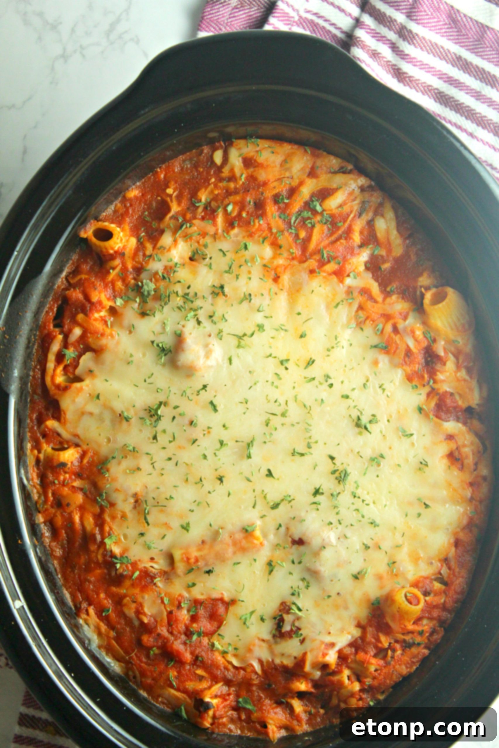 Set It and Forget It Cheesy Baked Ziti 3 Close-up of the rich, meaty sauce simmering in the slow cooker, mixed with ziti pasta before cheese is added.