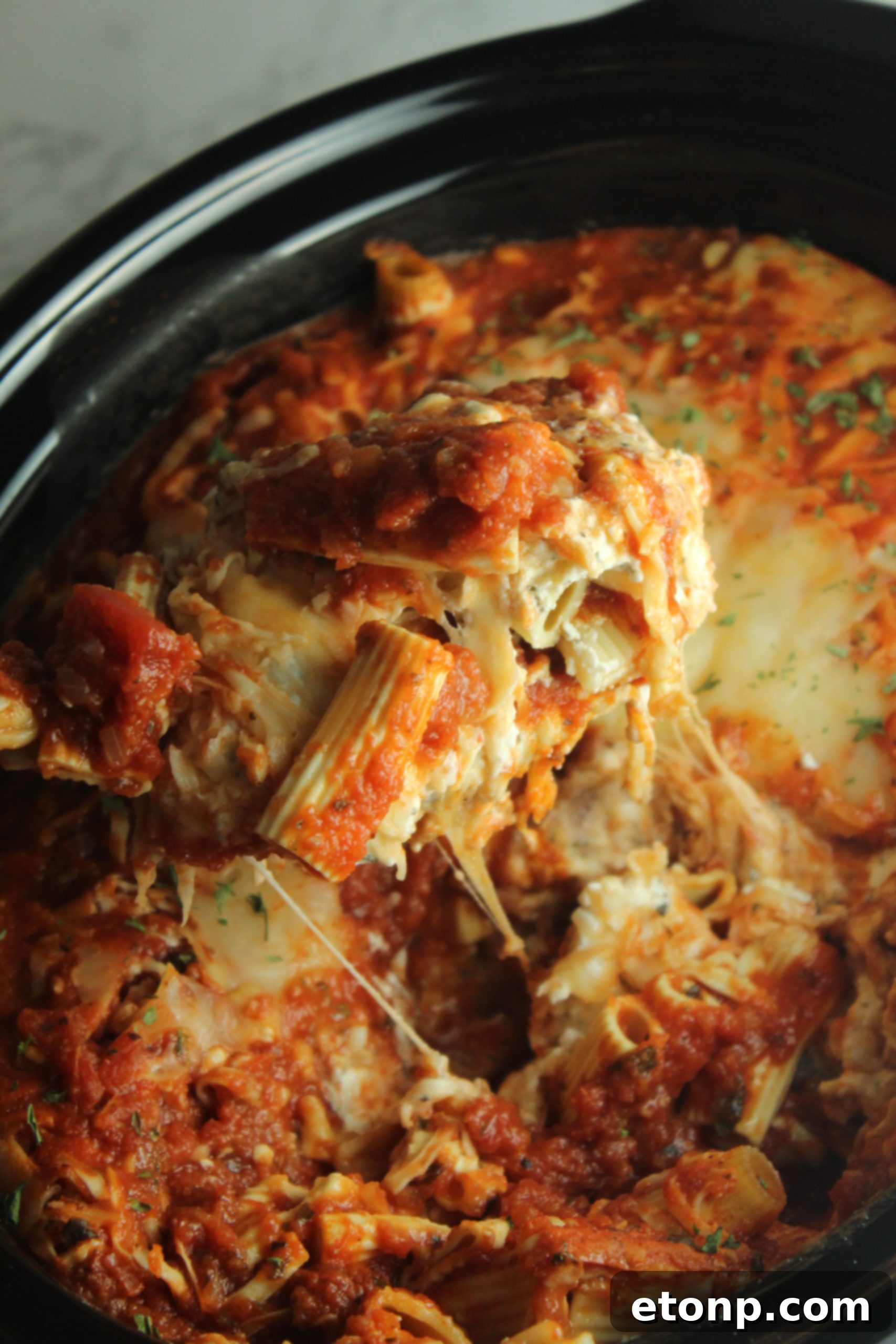Set It and Forget It Cheesy Baked Ziti 6 A serving of Slow Cooker Cheesy Baked Ziti with crusty garlic bread and a fresh green salad, making a complete meal.