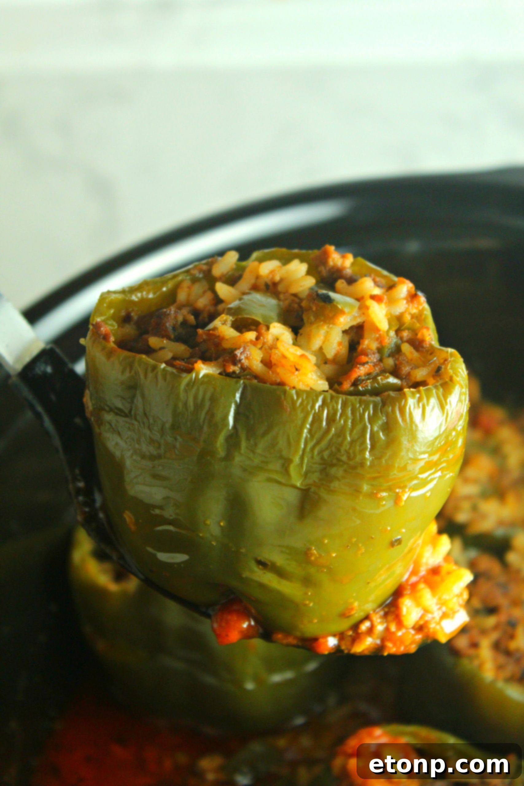 Effortless Slow Cooker Stuffed Peppers 5 A top-down view of several slow cooker stuffed peppers, perfectly cooked and glistening with tomato sauce, ready for serving.