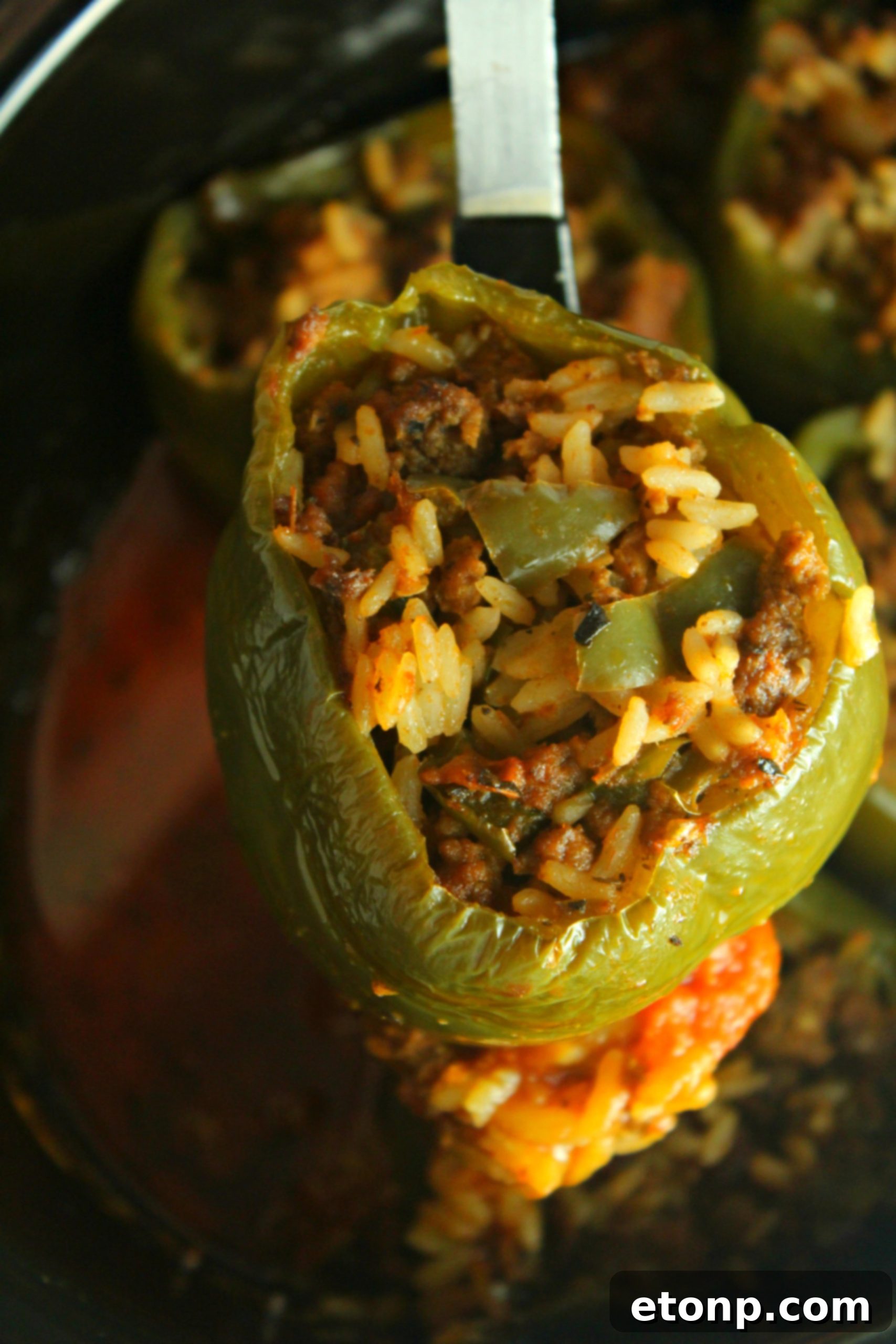 Effortless Slow Cooker Stuffed Peppers 6 Several raw bell peppers, prepped and ready to be stuffed, alongside a bowl of mixed ingredients for the filling.