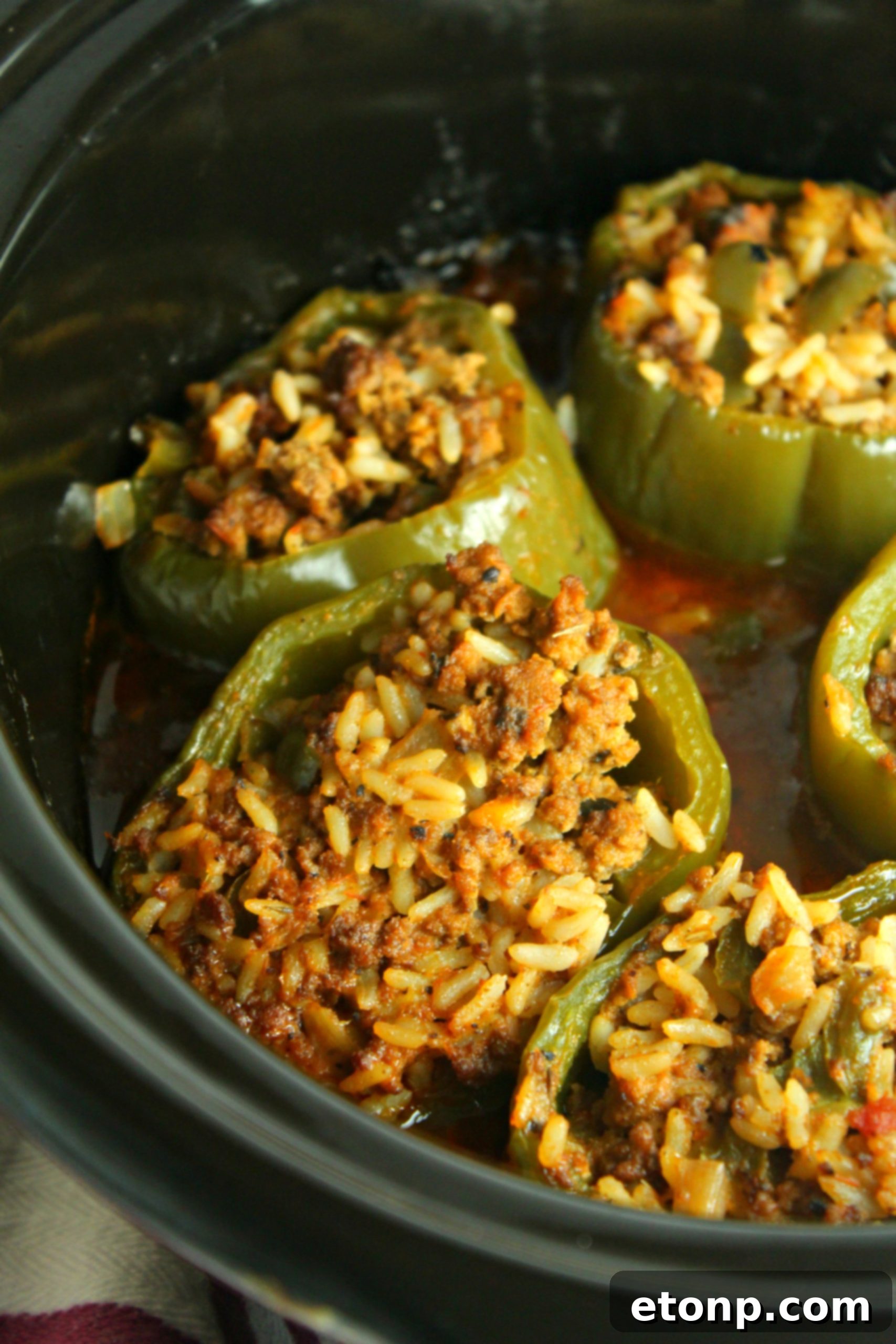 Effortless Slow Cooker Stuffed Peppers 8 A shot of the prepped bell peppers and the ingredients for the filling, including ground beef, rice, onions, and tomato sauce, laid out on a counter.