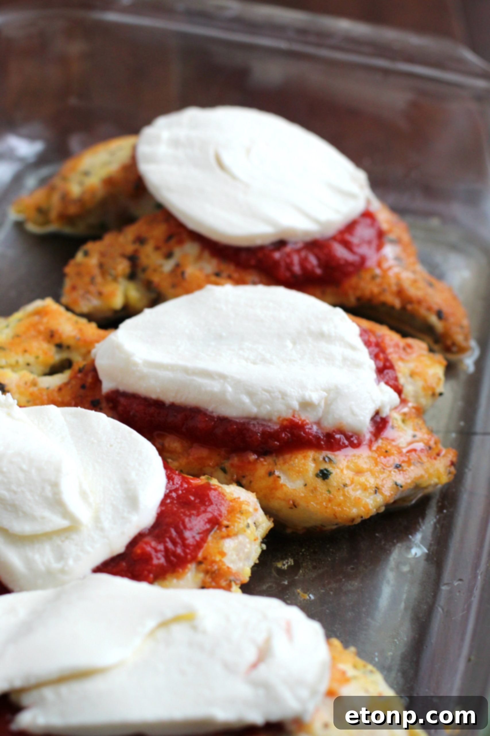 Keto Chicken Parmesan Perfection 4 A delicious serving of Keto Chicken Parmesan, topped with rich marinara sauce and fresh mozzarella, garnished with herbs