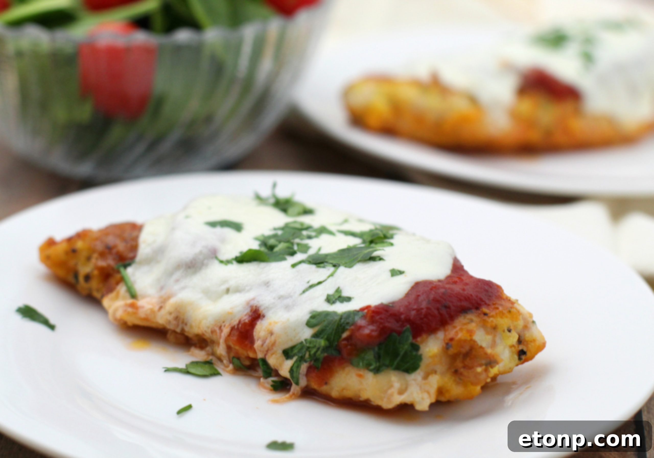 Keto Chicken Parmesan Perfection 6 A close-up shot of the melted mozzarella and crispy parmesan crust on a piece of Keto Chicken Parmesan, fresh from the oven