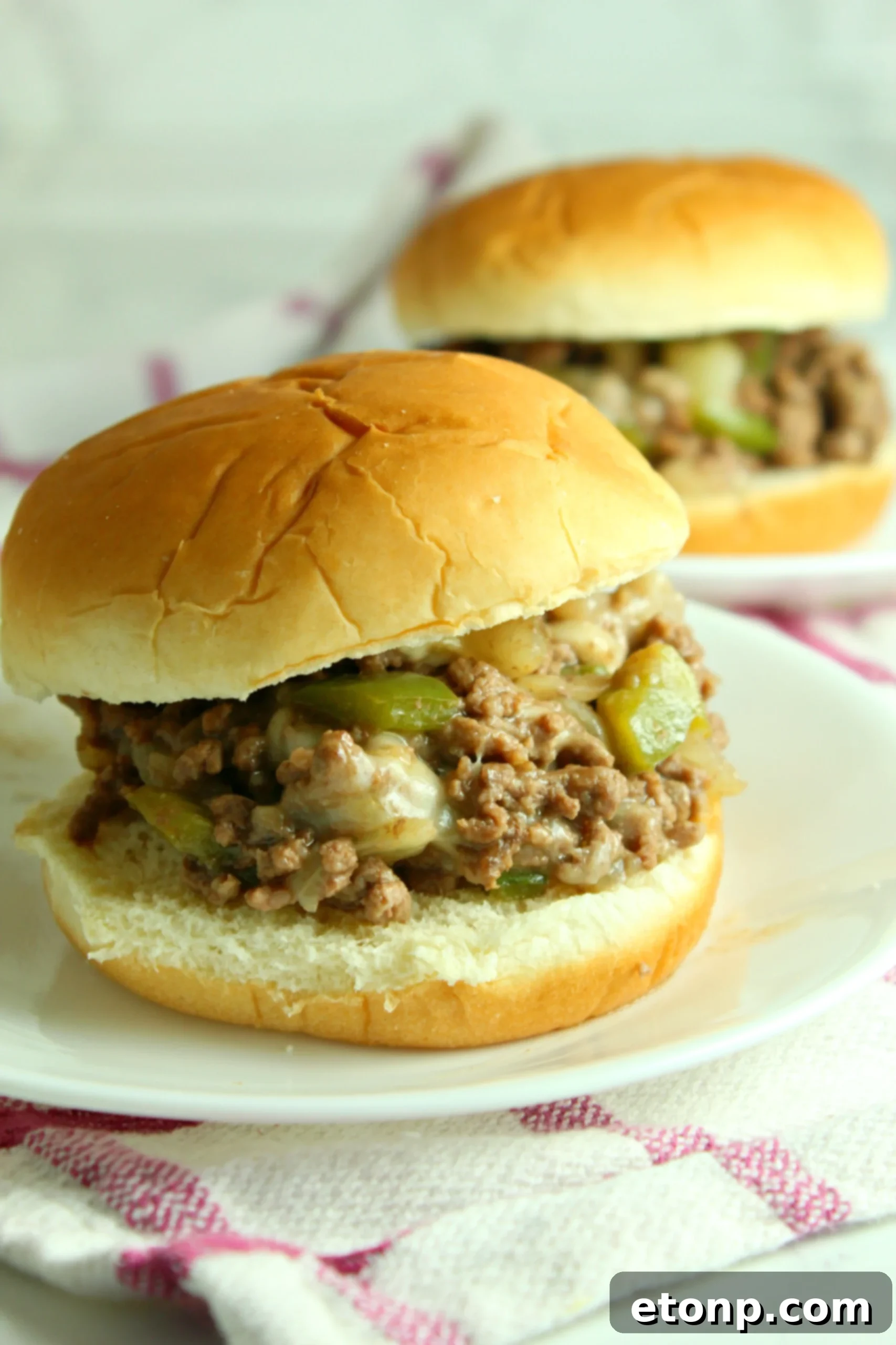 Delicious Cheesesteak Sloppy Joes served on a bun, showcasing gooey melted cheese and savory beef filling.