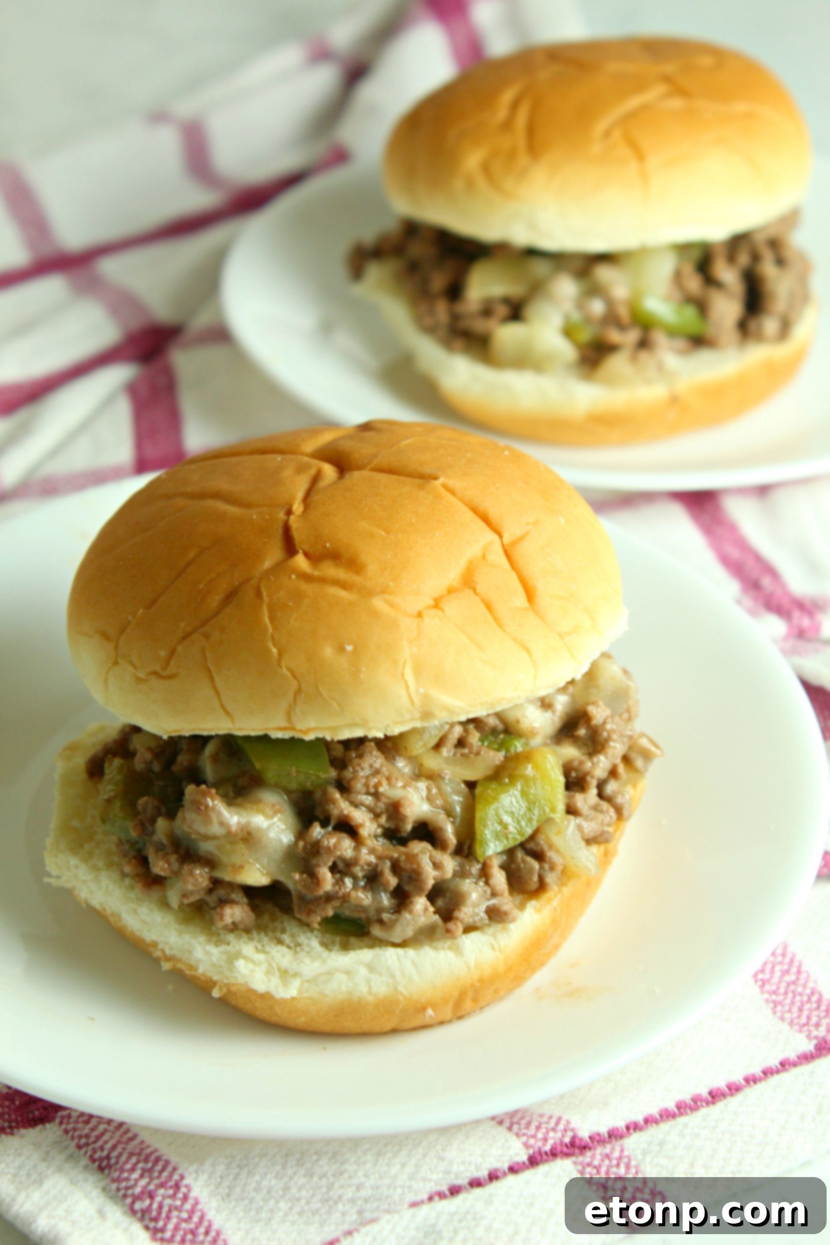 Overhead shot of Cheesesteak Sloppy Joes in a skillet, with melted cheese covering the beef and vegetables.