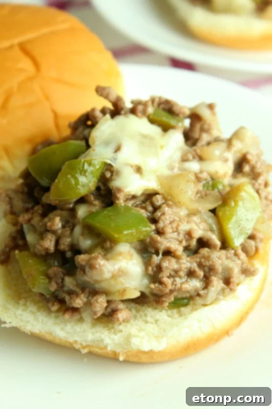 Close-up of a serving of Cheesesteak Sloppy Joes, highlighting the texture and melted cheese.