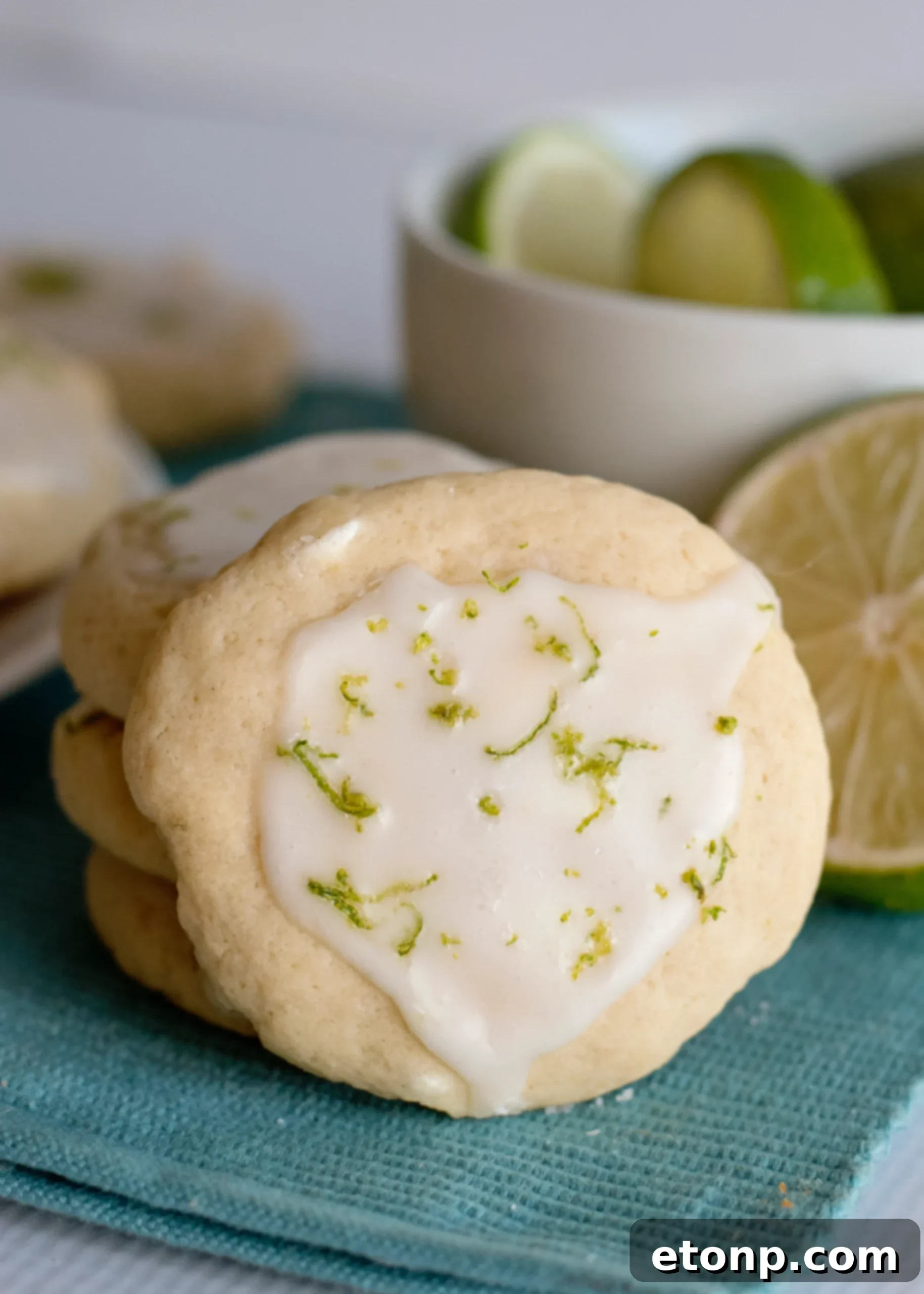 A close-up of a Key Lime Pie Cookie with a perfectly set glaze and lime zest