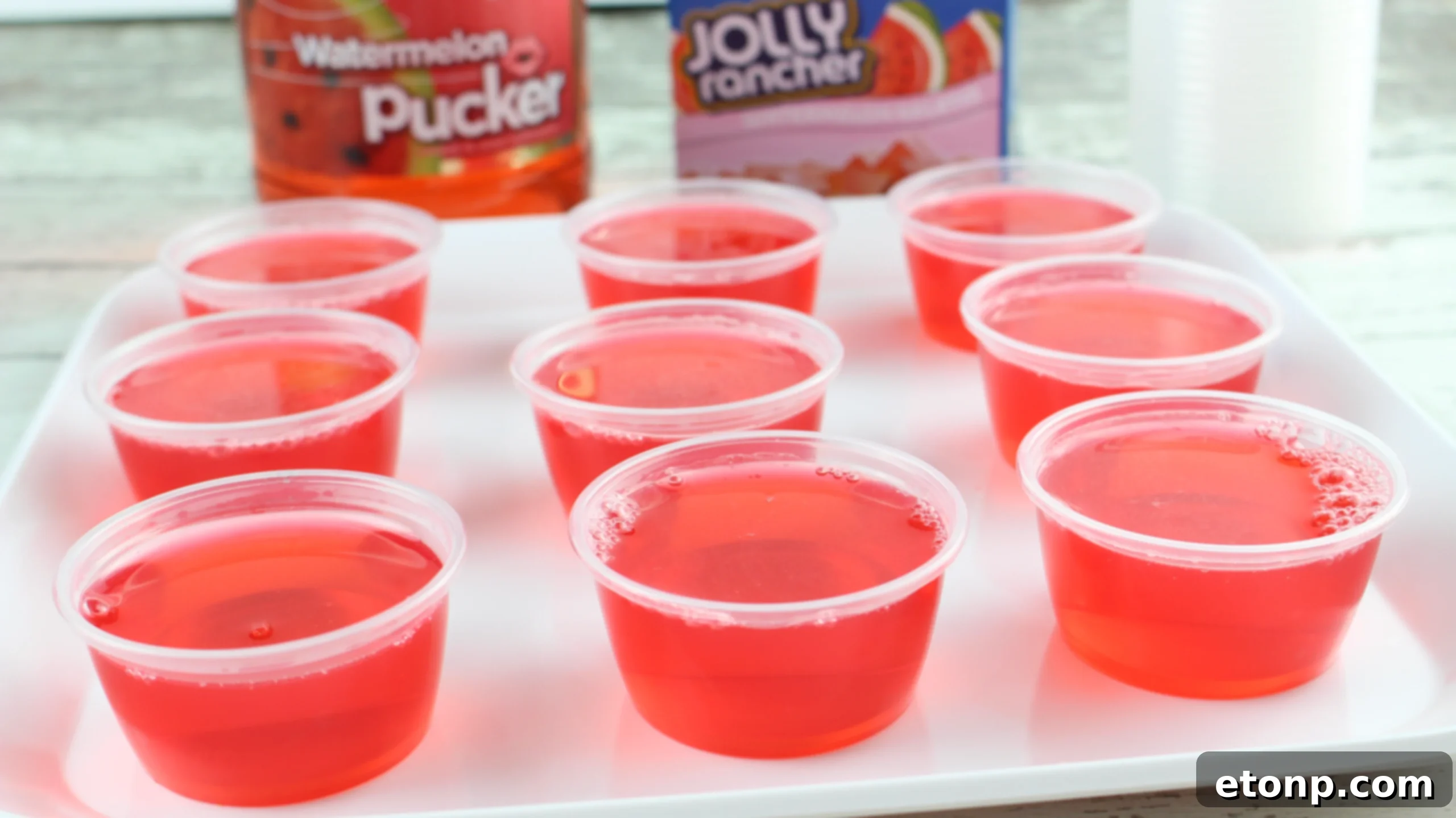 Overhead view of several Jolly Rancher Jello Shots with various colored candies scattered around