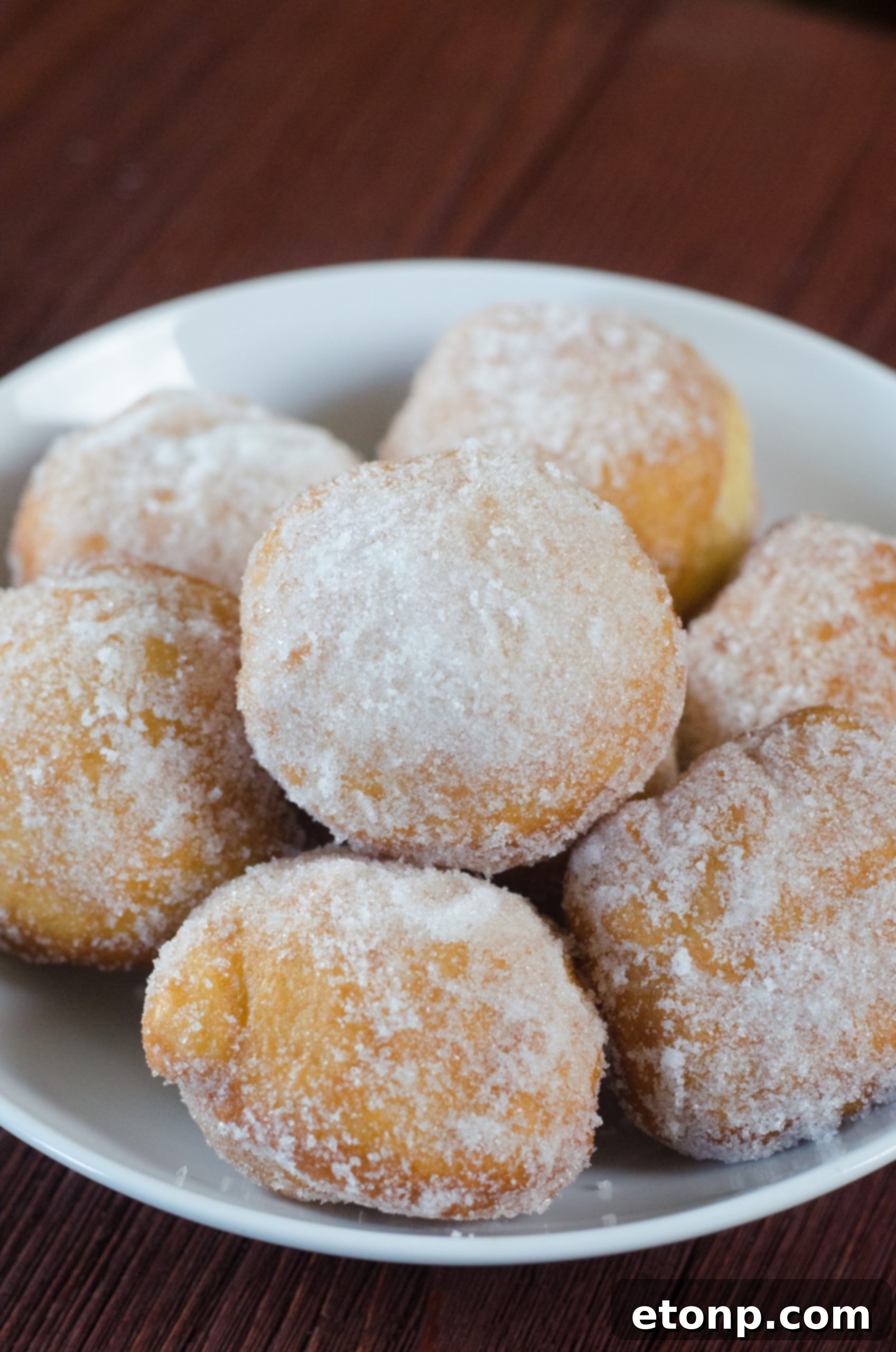 A single Chinese sugar donut with a visible filling, suggesting a delicious surprise inside, topped with powdered sugar.