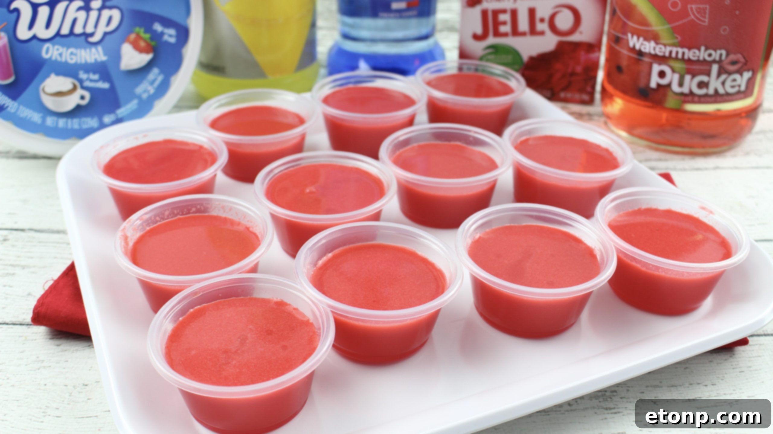 Cherry Starburst Jiggle Pops 5 A close-up of a single Cherry Starburst JELL-O Shot, showing the perfect layers of Jell-O and a creamy top, making it irresistible.