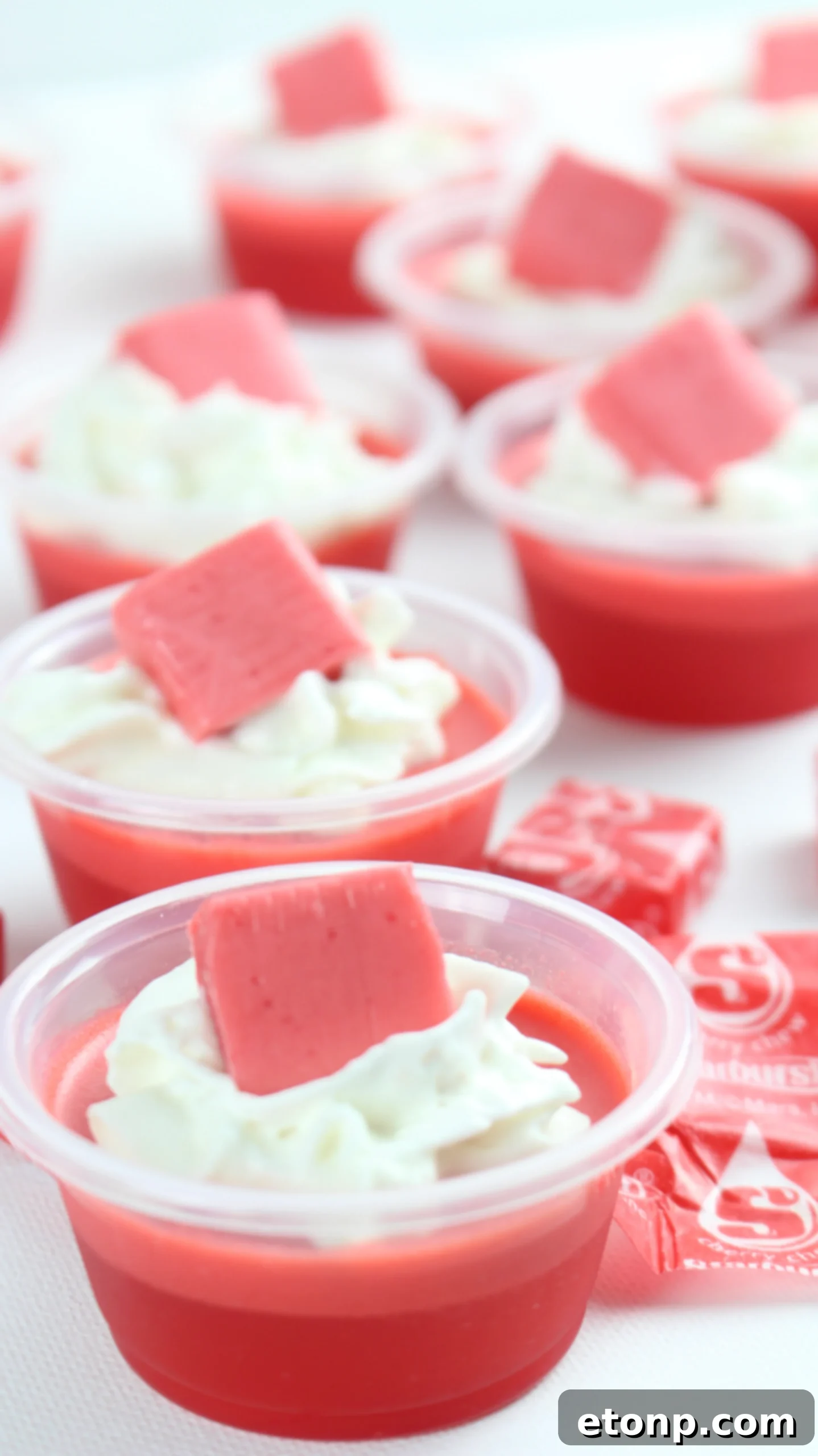 Cherry Starburst Jiggle Pops 9 Another array of colorful JELL-O shots, some with fruit garnishes, highlighting the festive and appealing nature of these party treats.