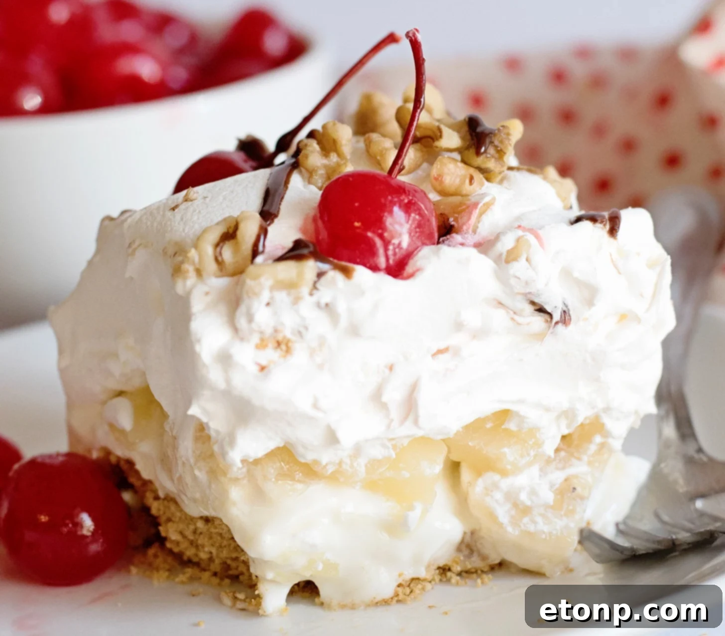 Delicious No-Bake Banana Split Dessert with layers of banana, pineapple, whipped cream, and cherries
