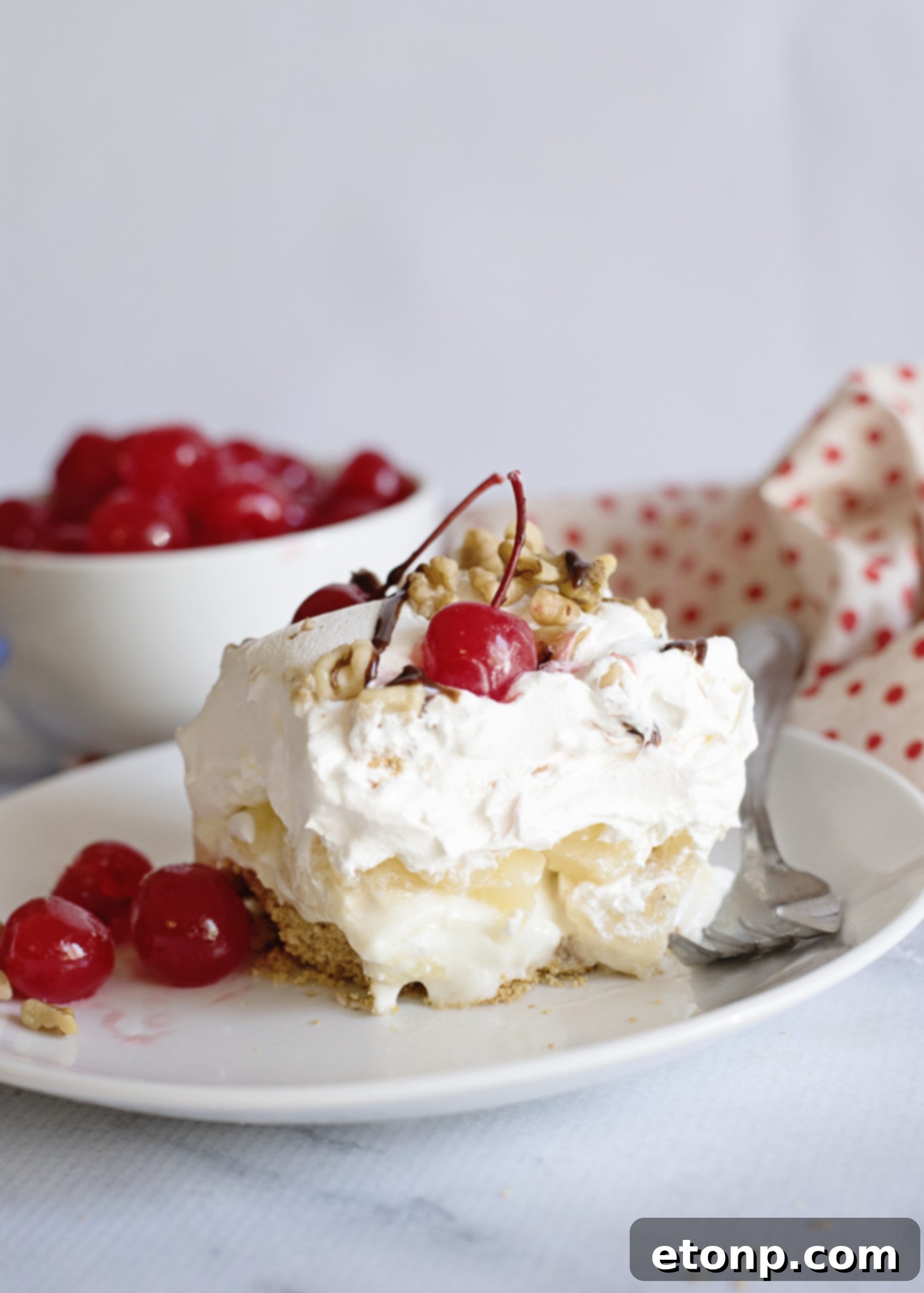 A full baking dish of No-Bake Banana Split Dessert with additional toppings on the side