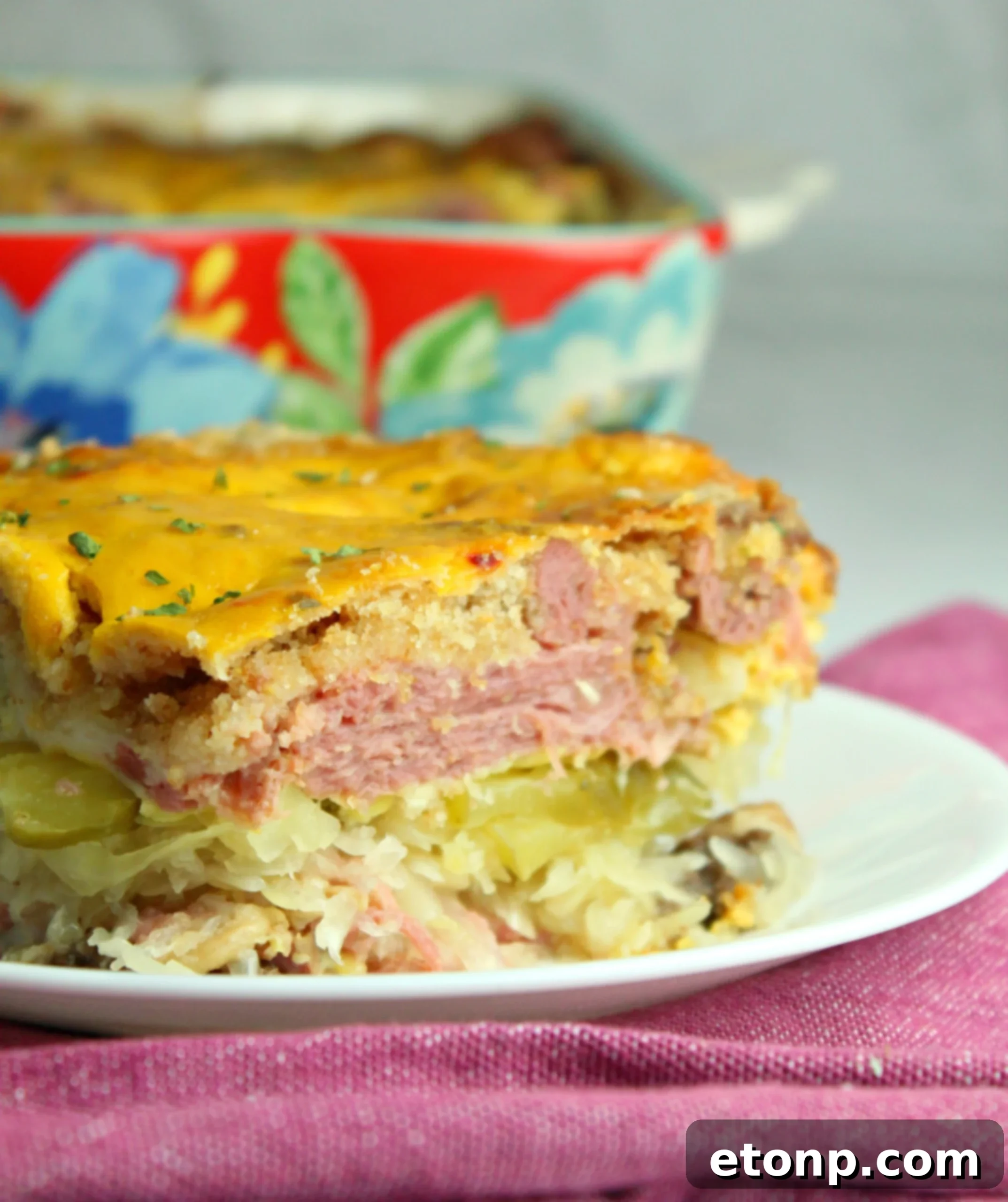 Melted Swiss cheese blanketing the corned beef and sauerkraut in the casserole, ready for more layers.