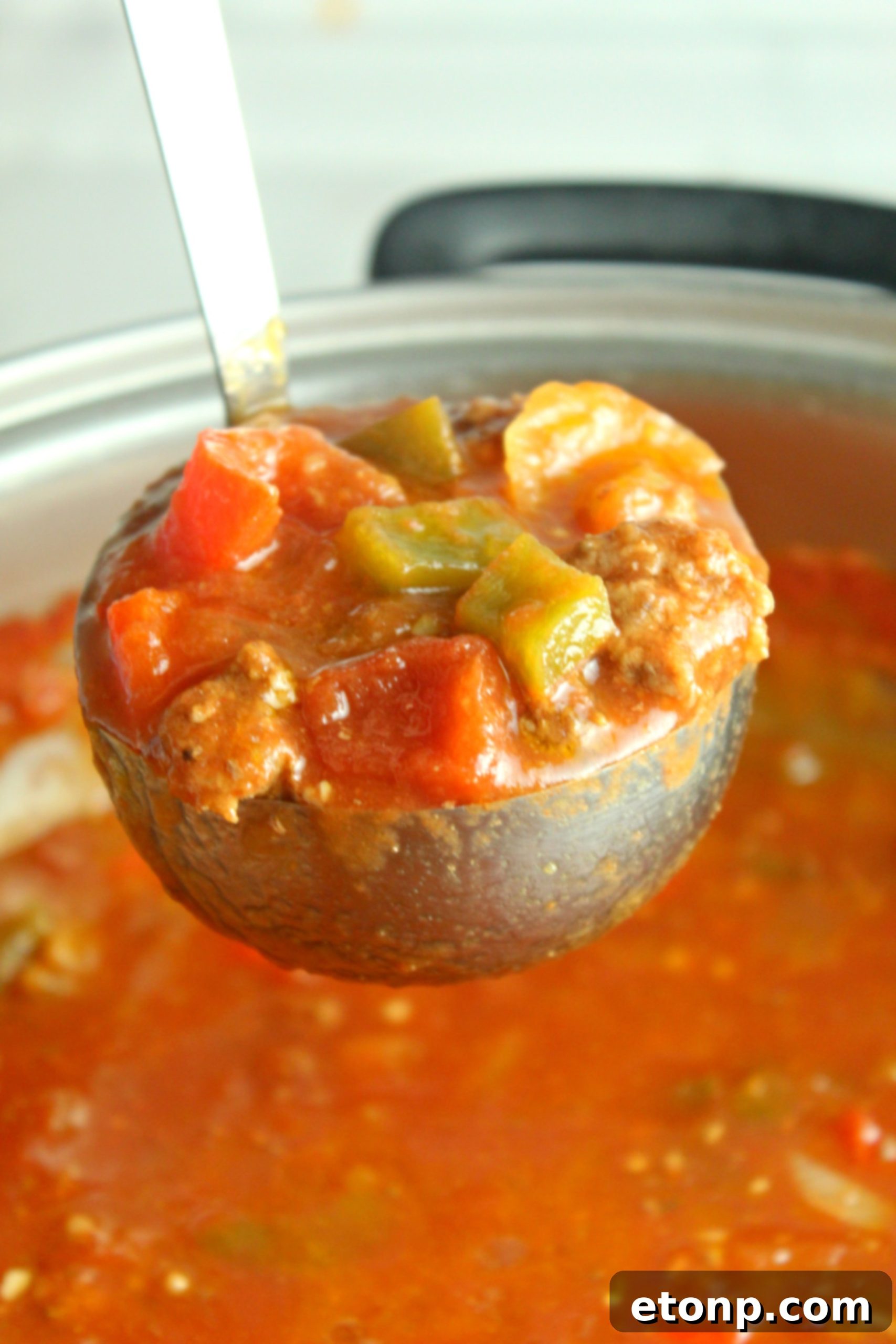 Homestyle Stuffed Pepper Stew 2 A steaming bowl of hearty stuffed pepper soup with ground beef and colorful bell peppers, garnished with fresh parsley.
