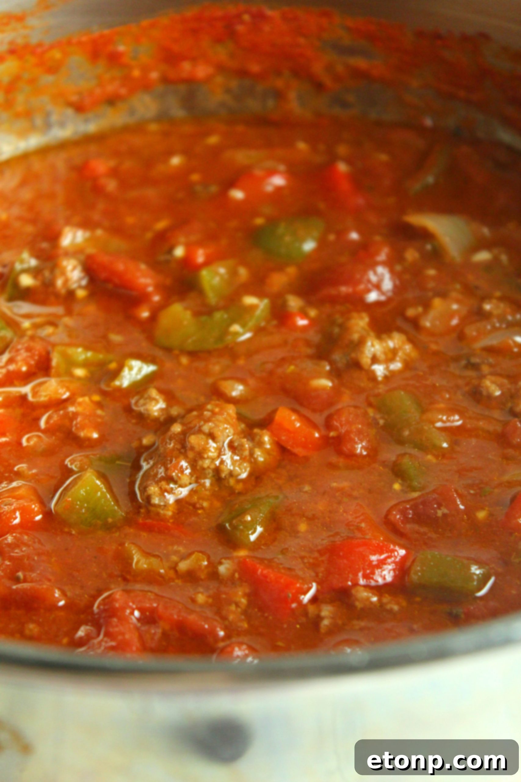 Homestyle Stuffed Pepper Stew 6 A close-up shot of the cooking process of stuffed pepper soup in a large pot on the stove.