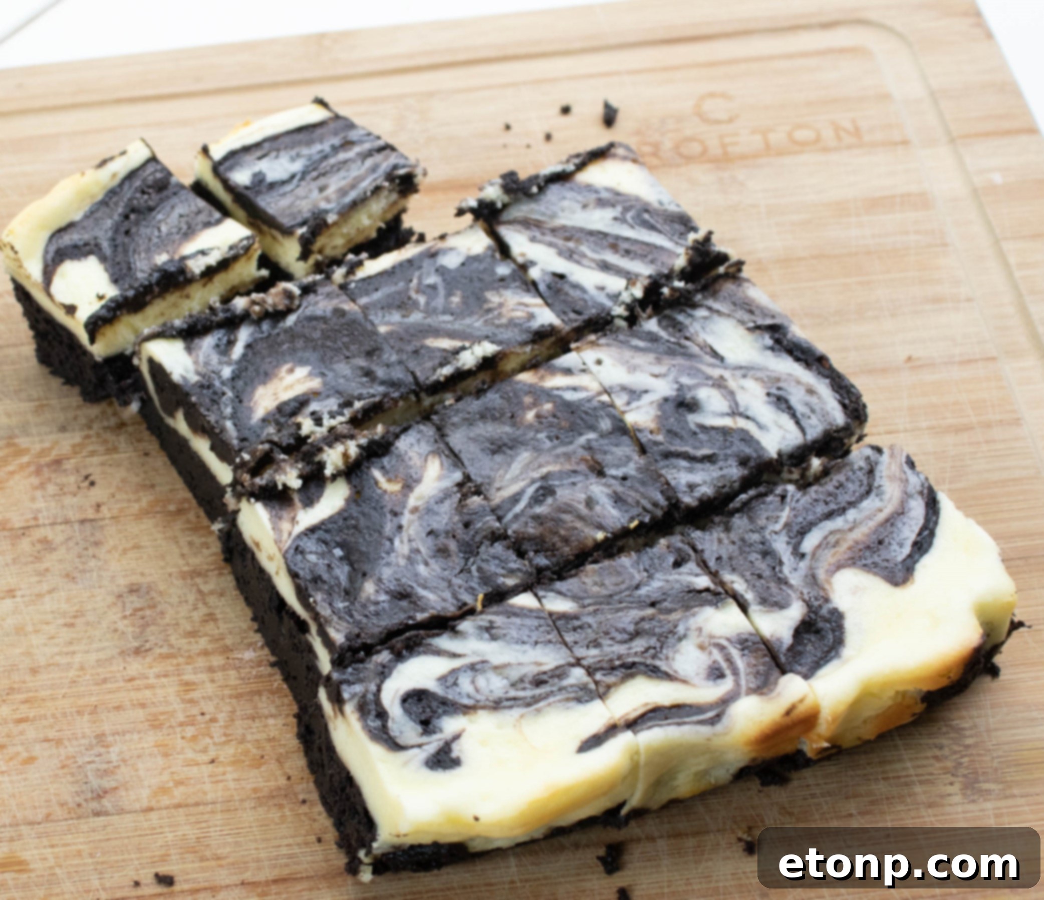 Homemade Cheesecake Swirl Brownies 3 A close-up of a square pan filled with baked cheesecake swirl brownies, displaying the beautiful marbled effect of chocolate and cream cheese.