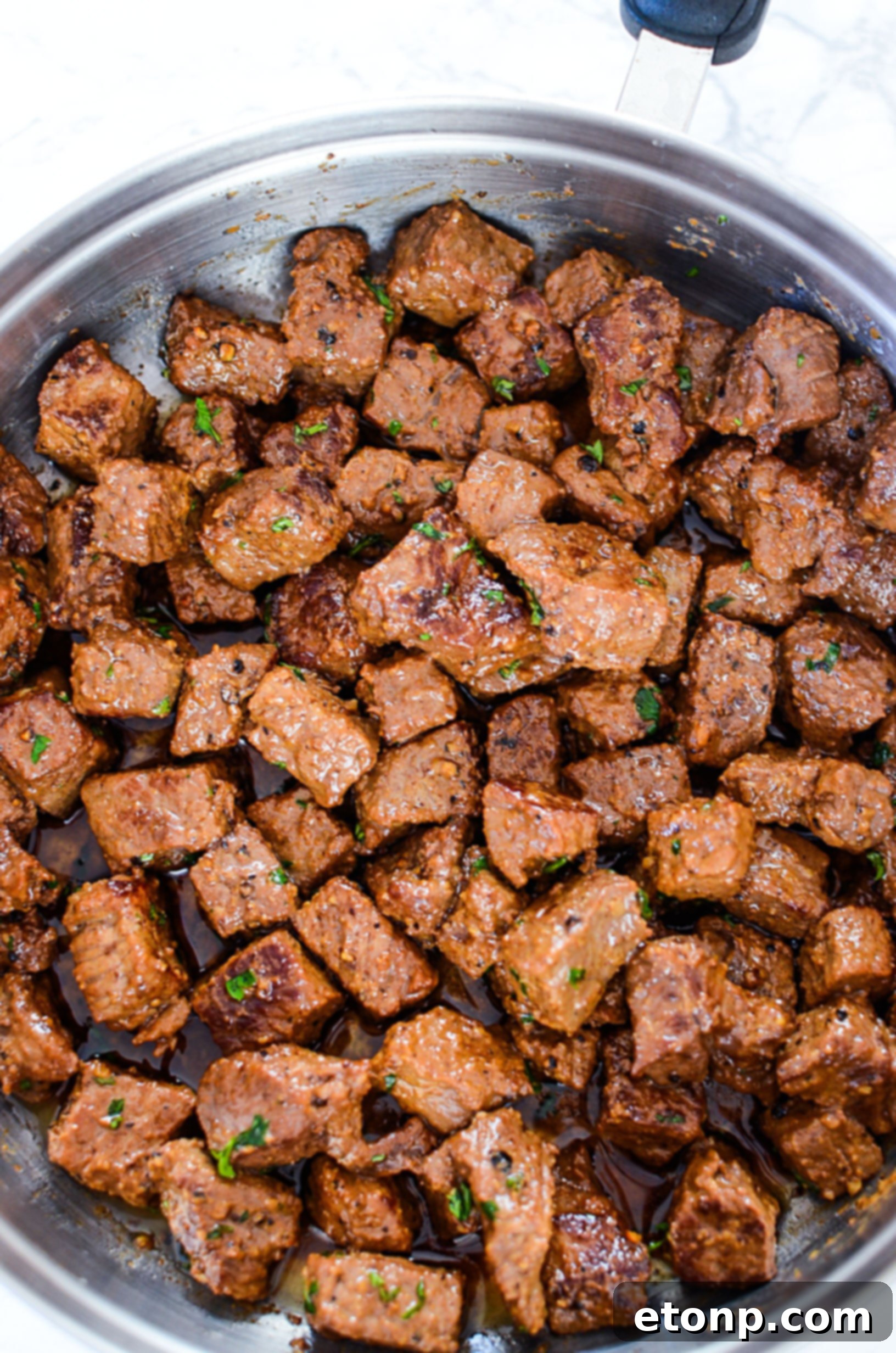 Steak bites sizzling in a hot skillet, creating a beautiful crust.