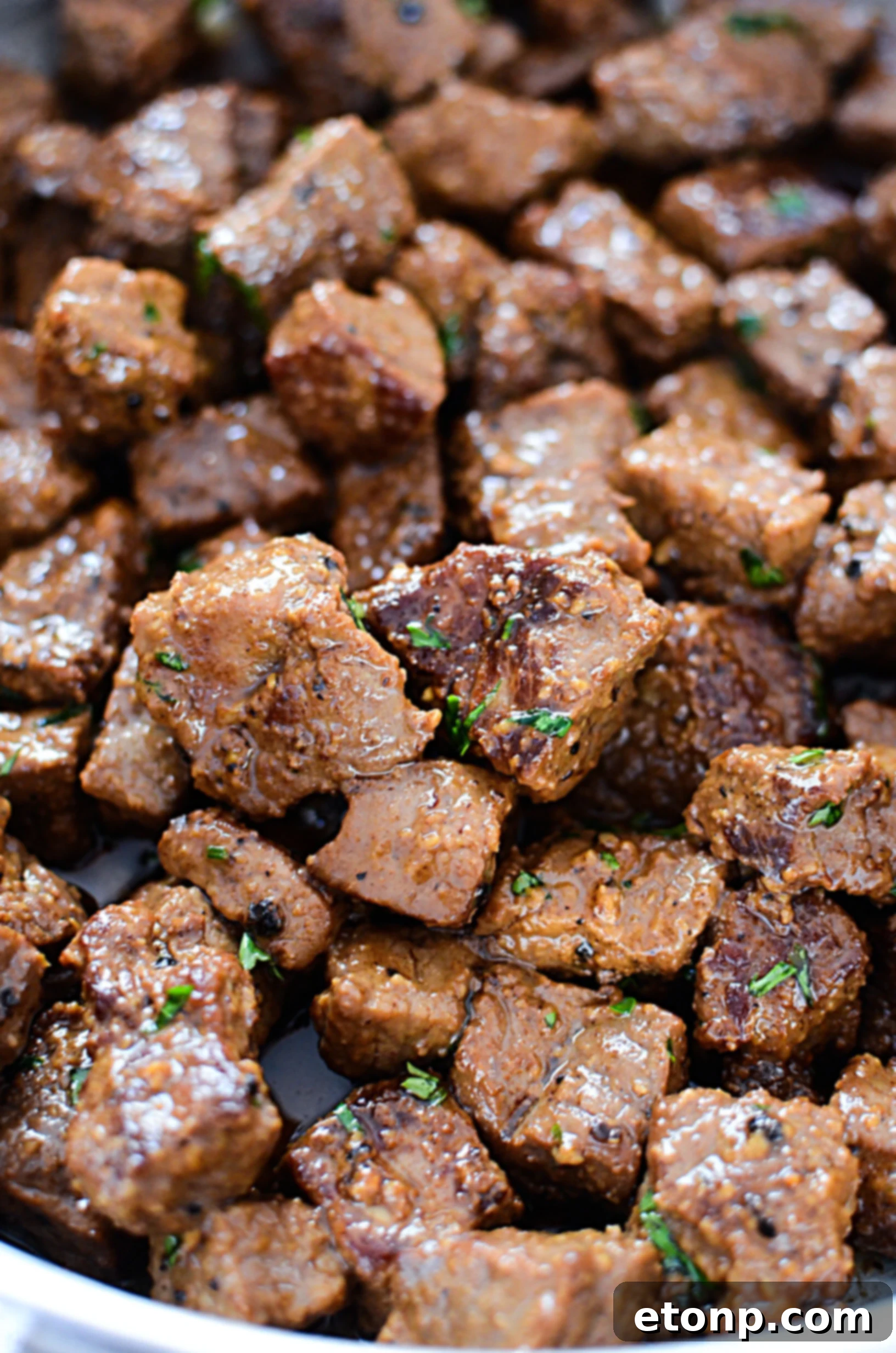 Garlic butter steak bites served on a plate with various side dishes like mashed potatoes and green beans.