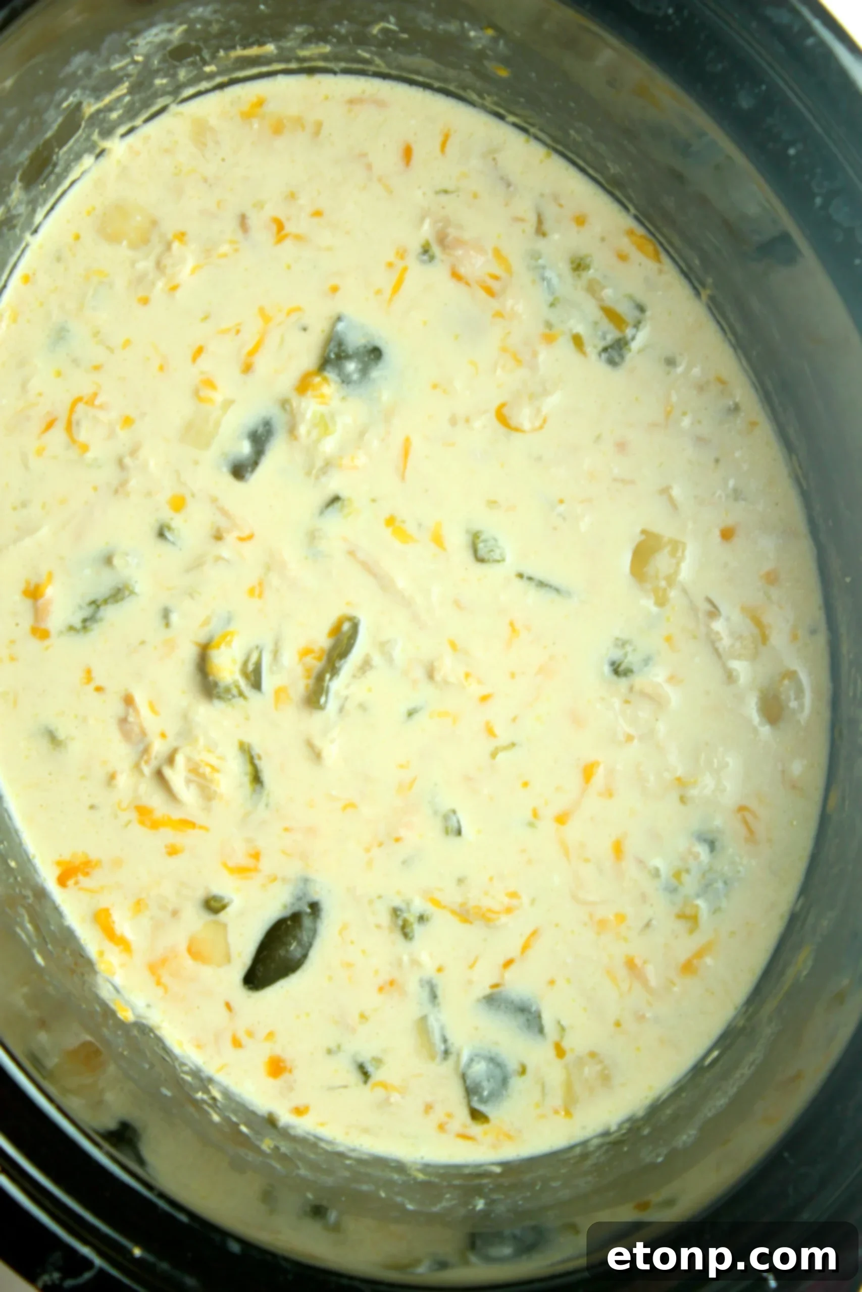 A vibrant display of fresh ingredients for Slow Cooker Chicken Chile Rellenos Soup, including poblano peppers, chicken, onion, and cheese