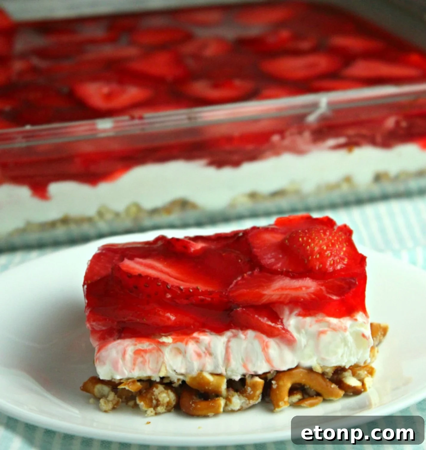 A vibrant Strawberry Pretzel Salad with a crunchy pretzel crust, creamy white filling, and a bright red strawberry Jell-O topping, perfect for any gathering.