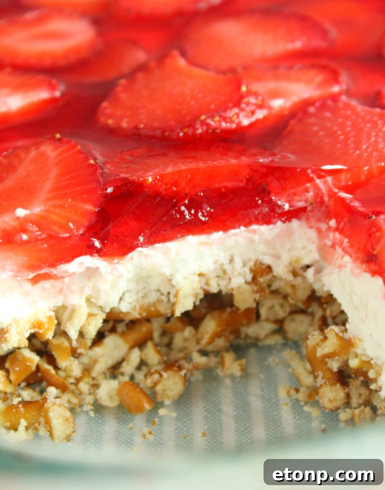 A large pan of Strawberry Pretzel Salad, showcasing the smooth cream cheese layer beneath the strawberry Jell-O.