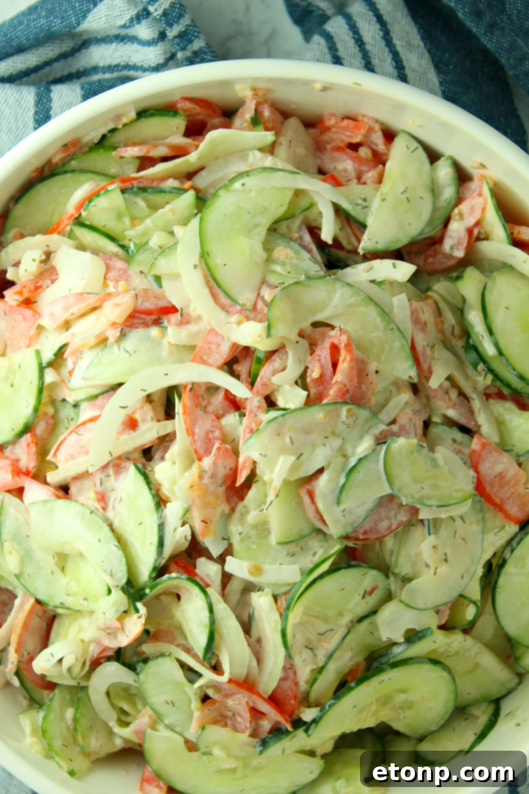 A beautifully presented creamy cucumber tomato salad, ready to be served and enjoyed at any gathering.