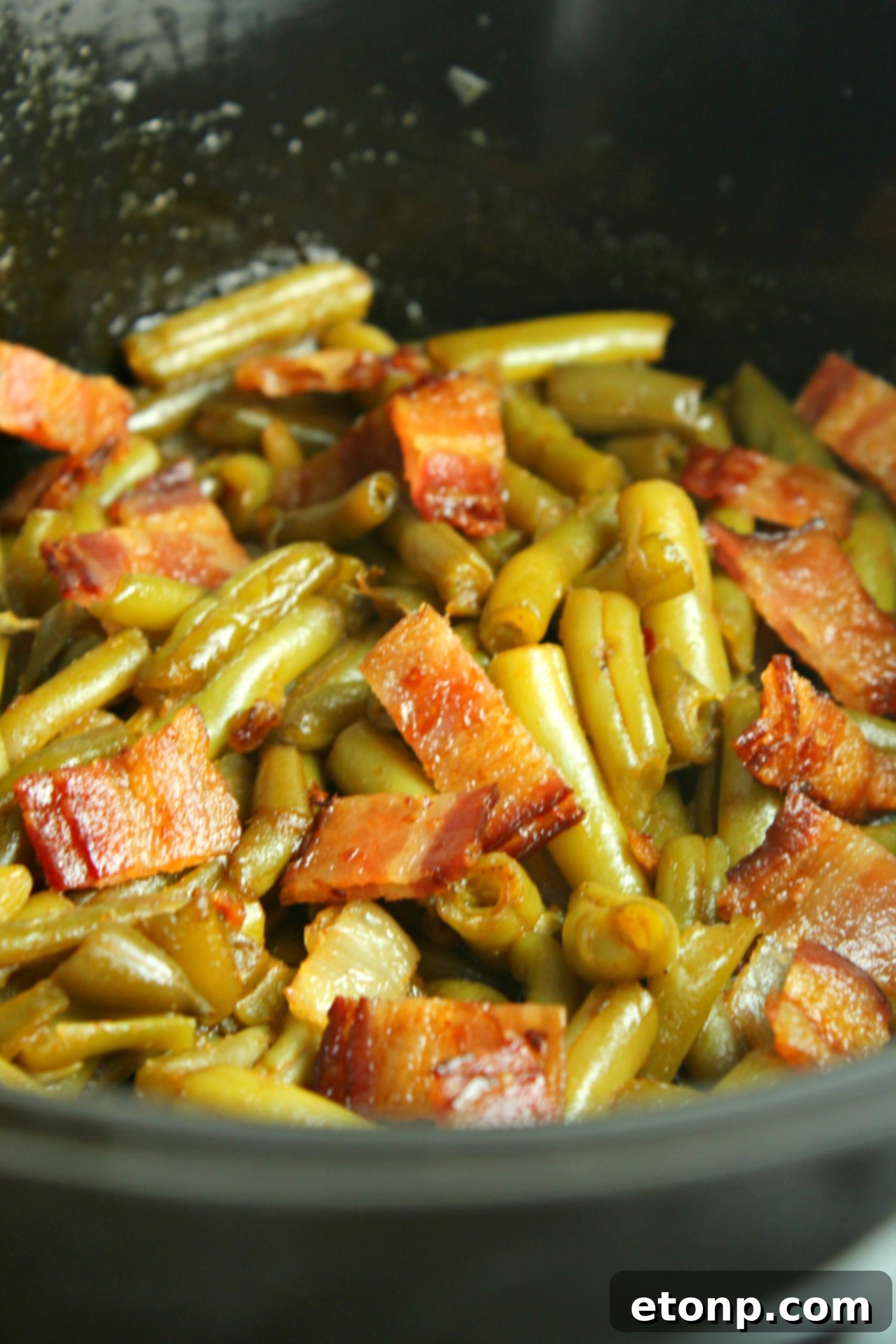 Ingredients for Slow Cooker Buttery Bacon Green Beans laid out, including butter, garlic, and bacon