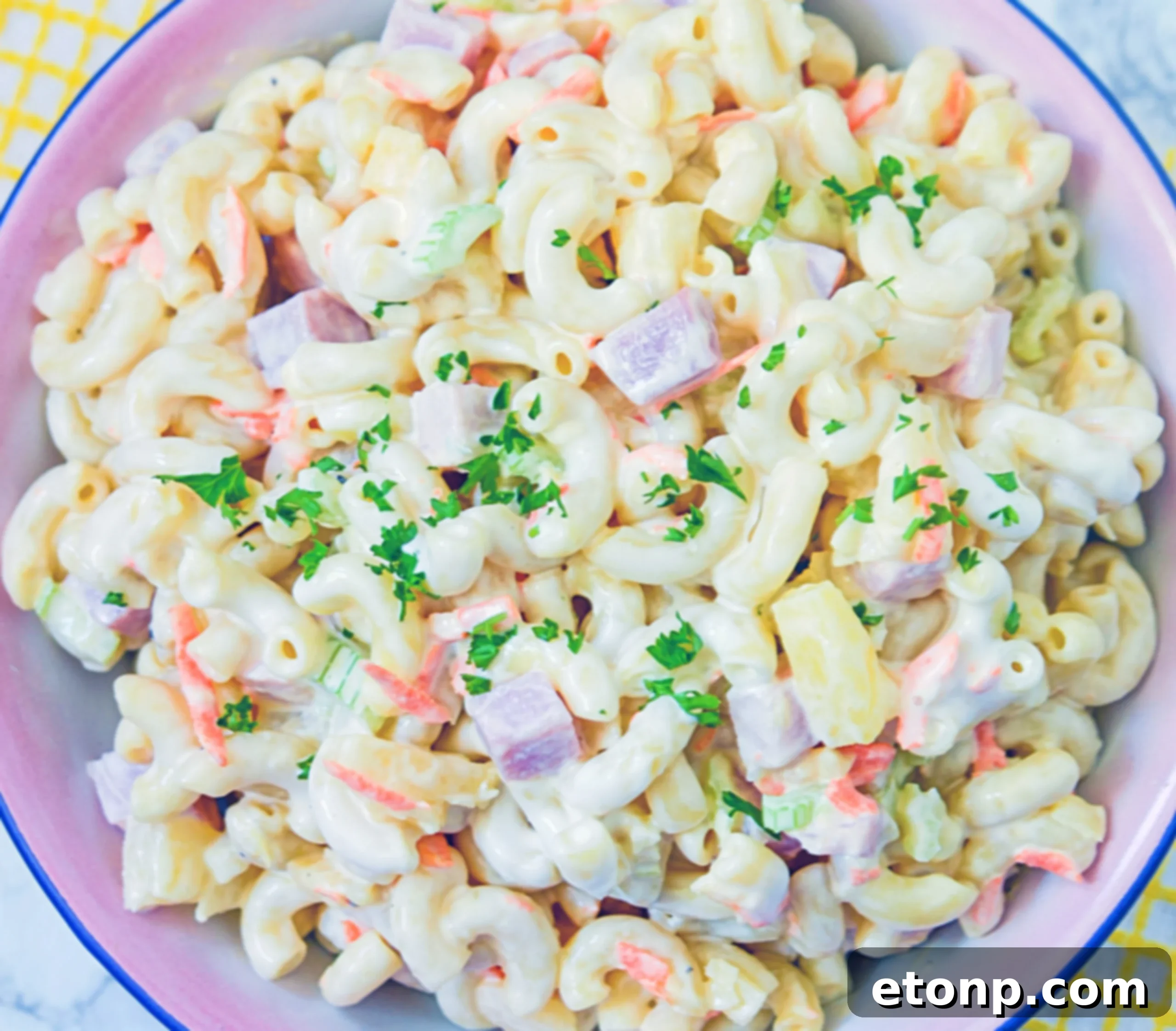 Island Macaroni Bliss 7 Close-up of creamy Hawaiian Macaroni Salad with diced ham and pineapple chunks.