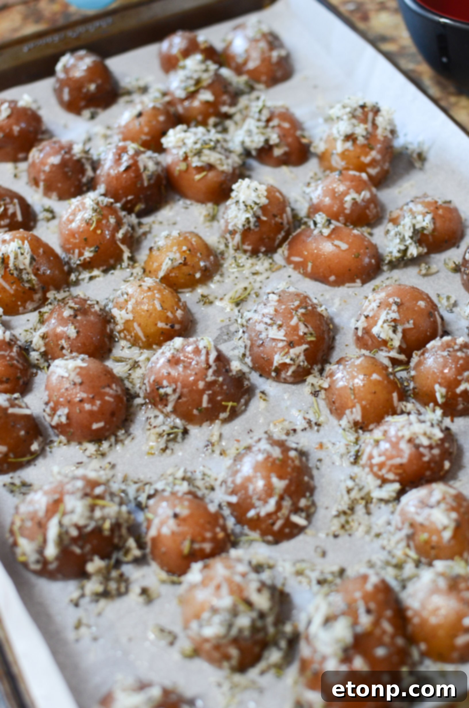 Platter of freshly baked Parmesan Crusted Roasted Potatoes, golden and enticing, ready to be served.