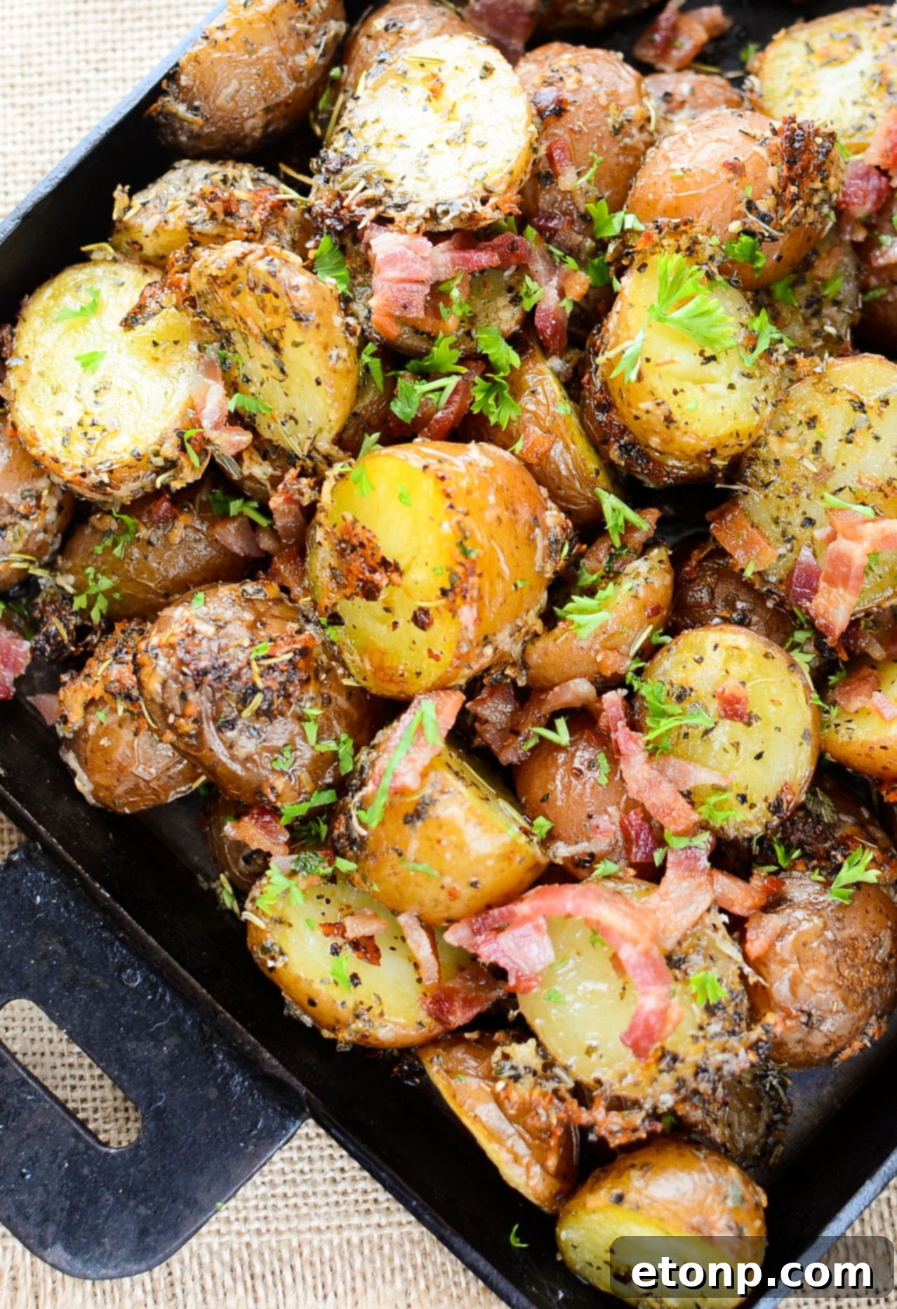 Overhead shot of Parmesan Crusted Roasted Potatoes in a large ceramic baking dish, ready to be served family style.