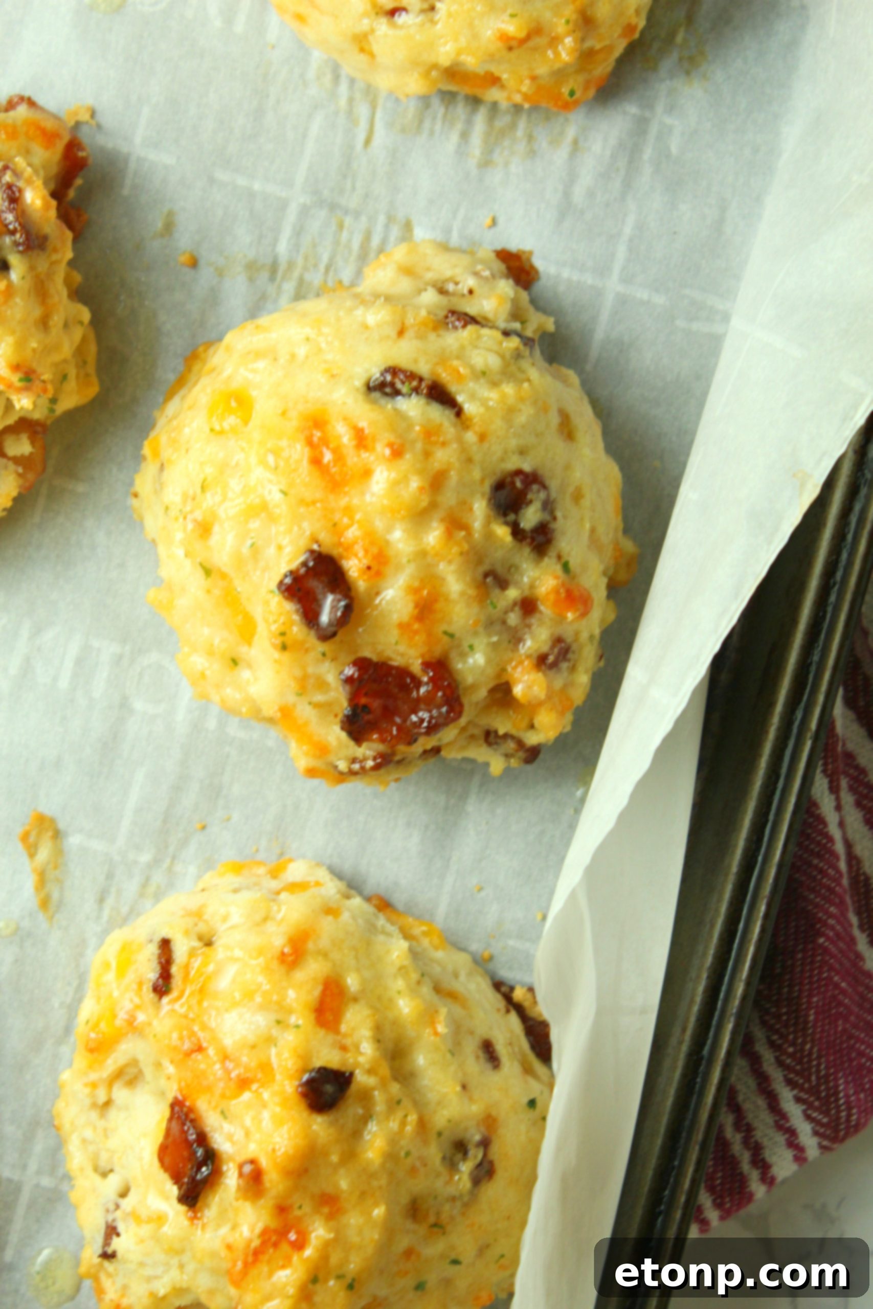 Two Cheesy Bacon Garlic Biscuits on a plate, ready to be served, showing their appealing golden color.
