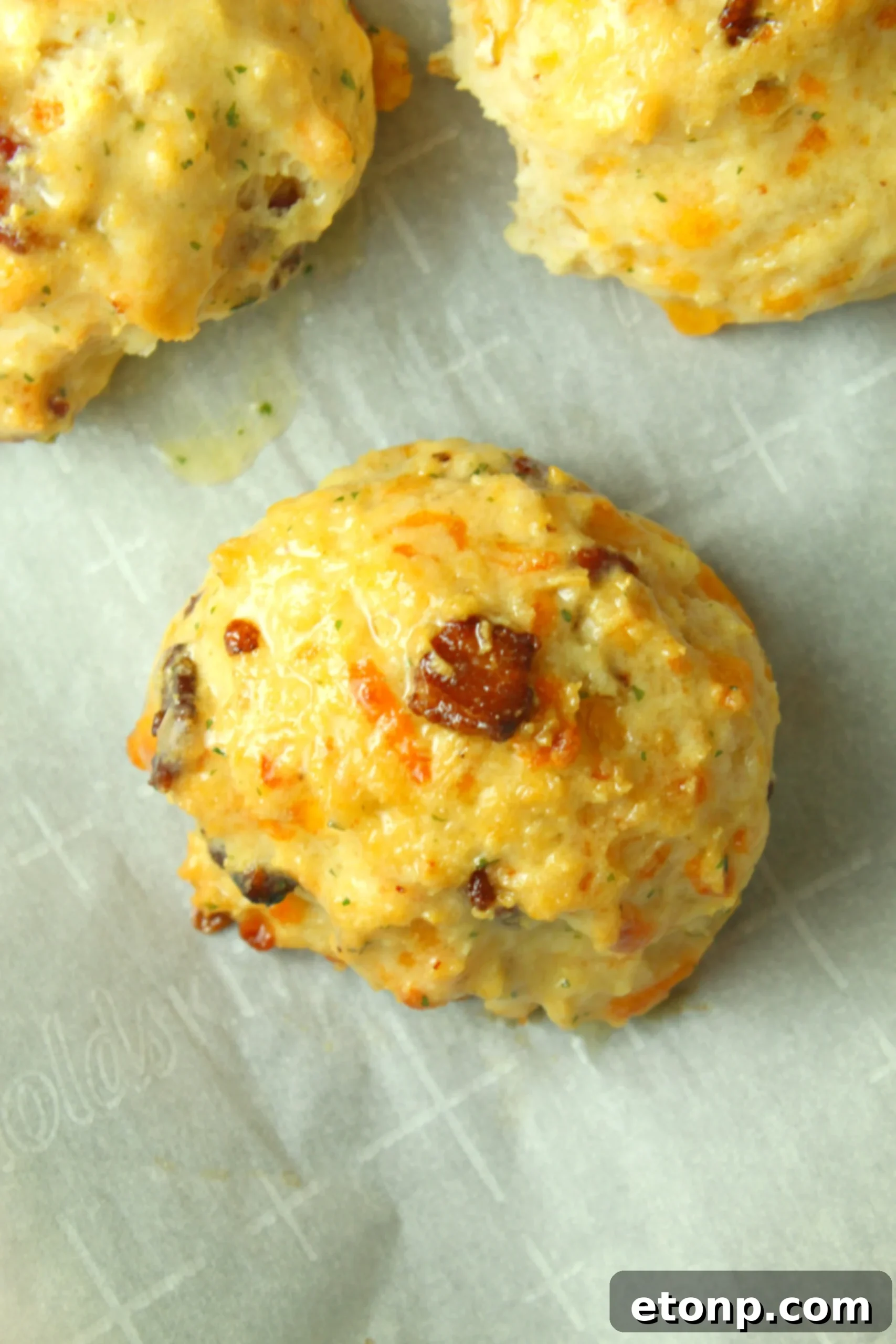 A mixing bowl with biscuit dough, cheese, and bacon, illustrating the preparation process.