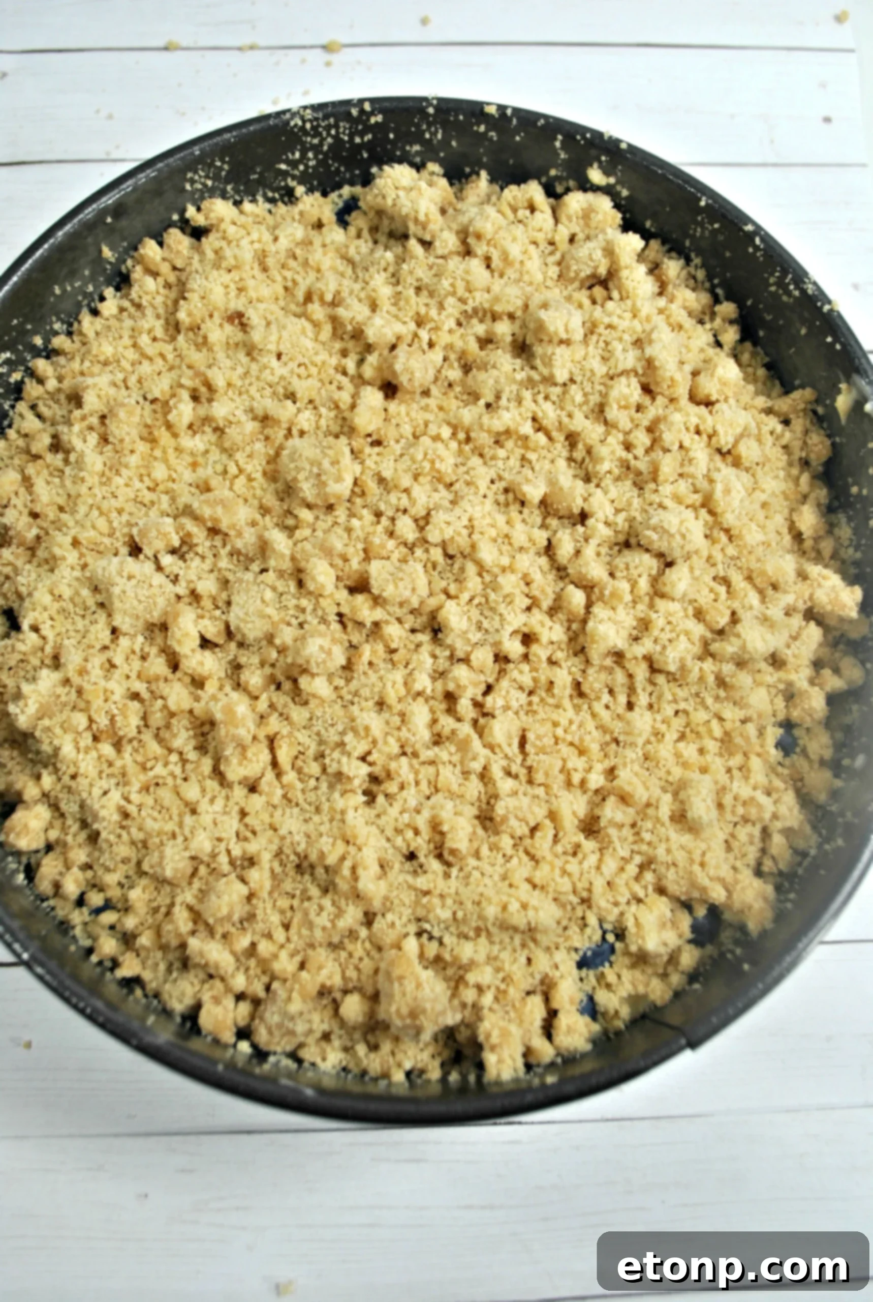 A whole Blueberry Cream Cheese Coffee Cake cooling on a wire rack, ready to be sliced.