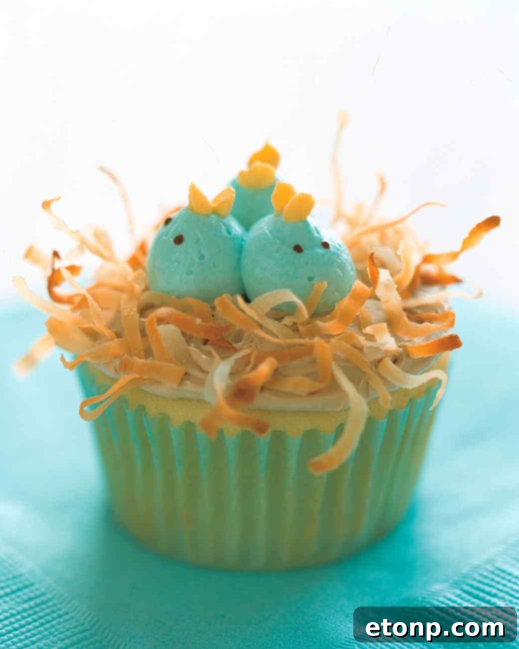 Bright yellow Easter Chick Cupcakes with candy eyes and orange beaks