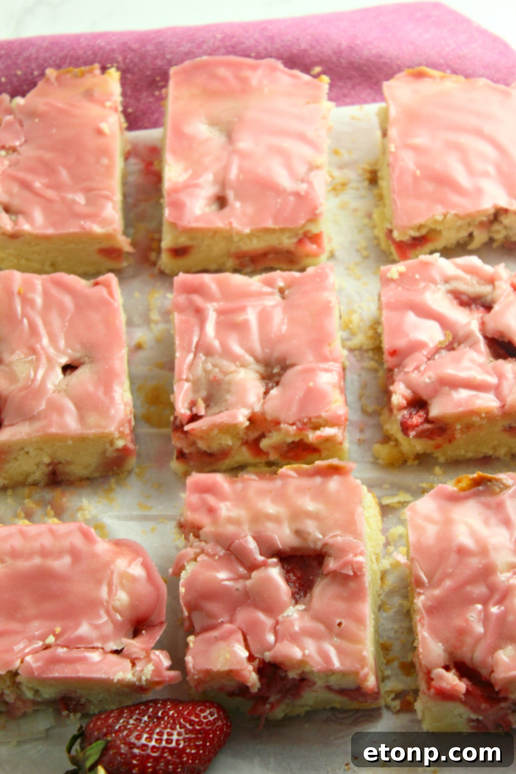 Homemade Strawberry Lemon Blondies 4 Strawberry lemon blondies generously topped with vibrant pink icing and fresh strawberry slices