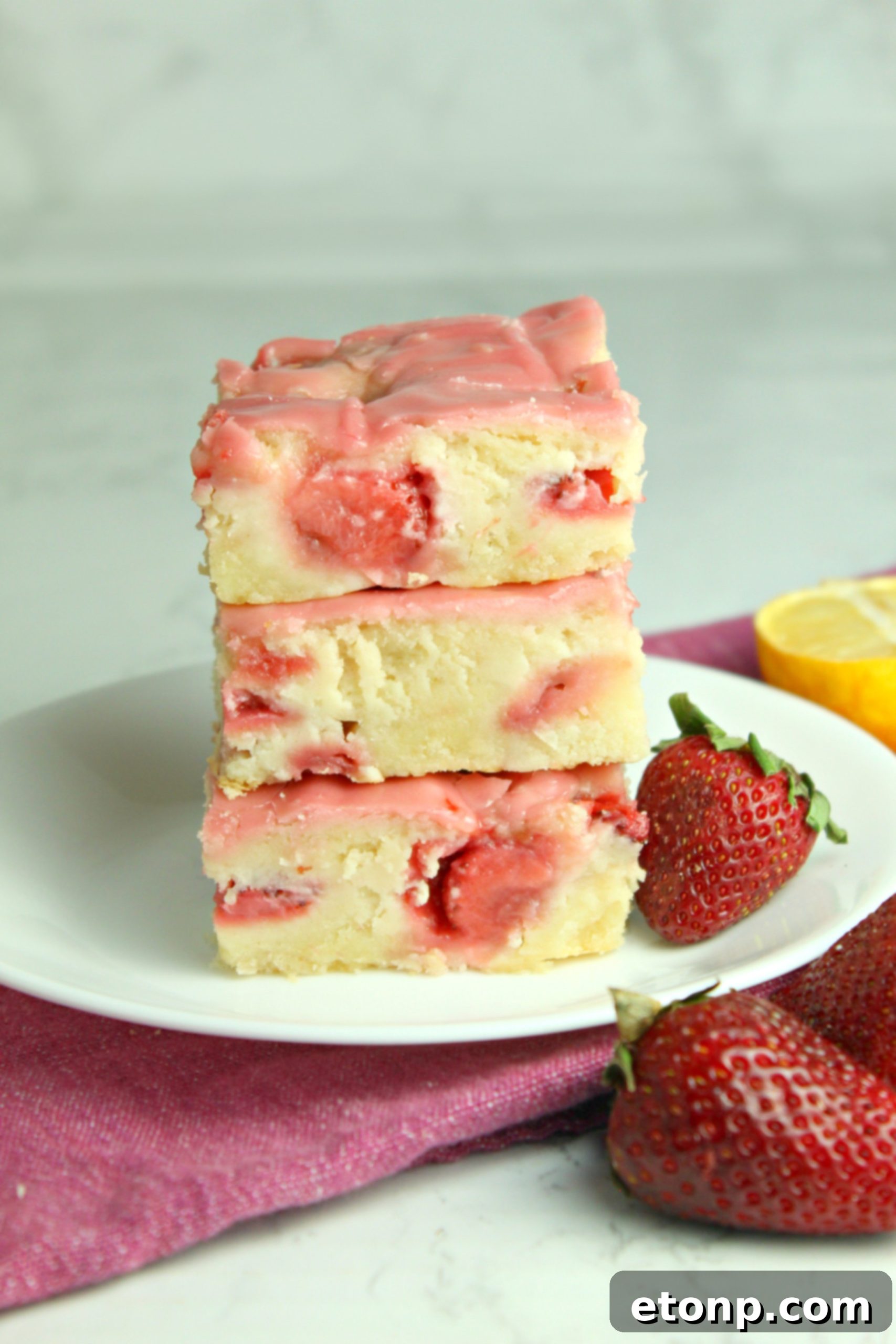 Homemade Strawberry Lemon Blondies 7 A close-up of a strawberry lemon blondie on a rustic wooden surface, highlighting its texture