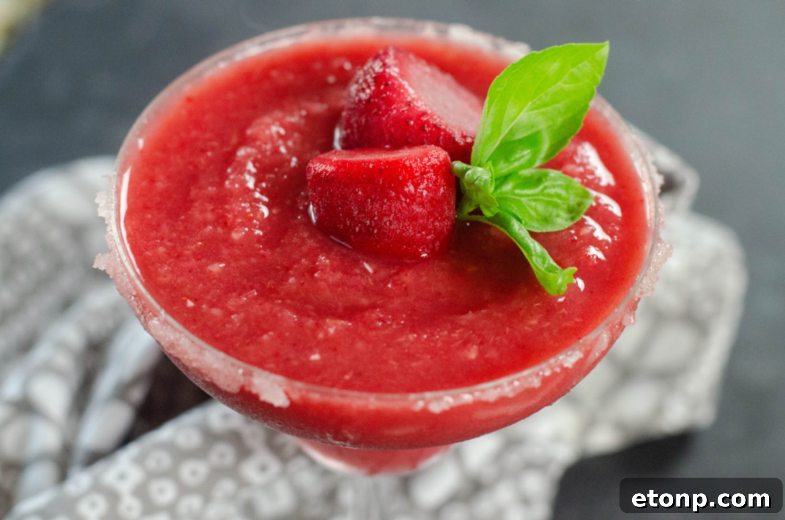 Close-up shot of fresh and frozen strawberries, highlighting the primary ingredients for the daiquiri.