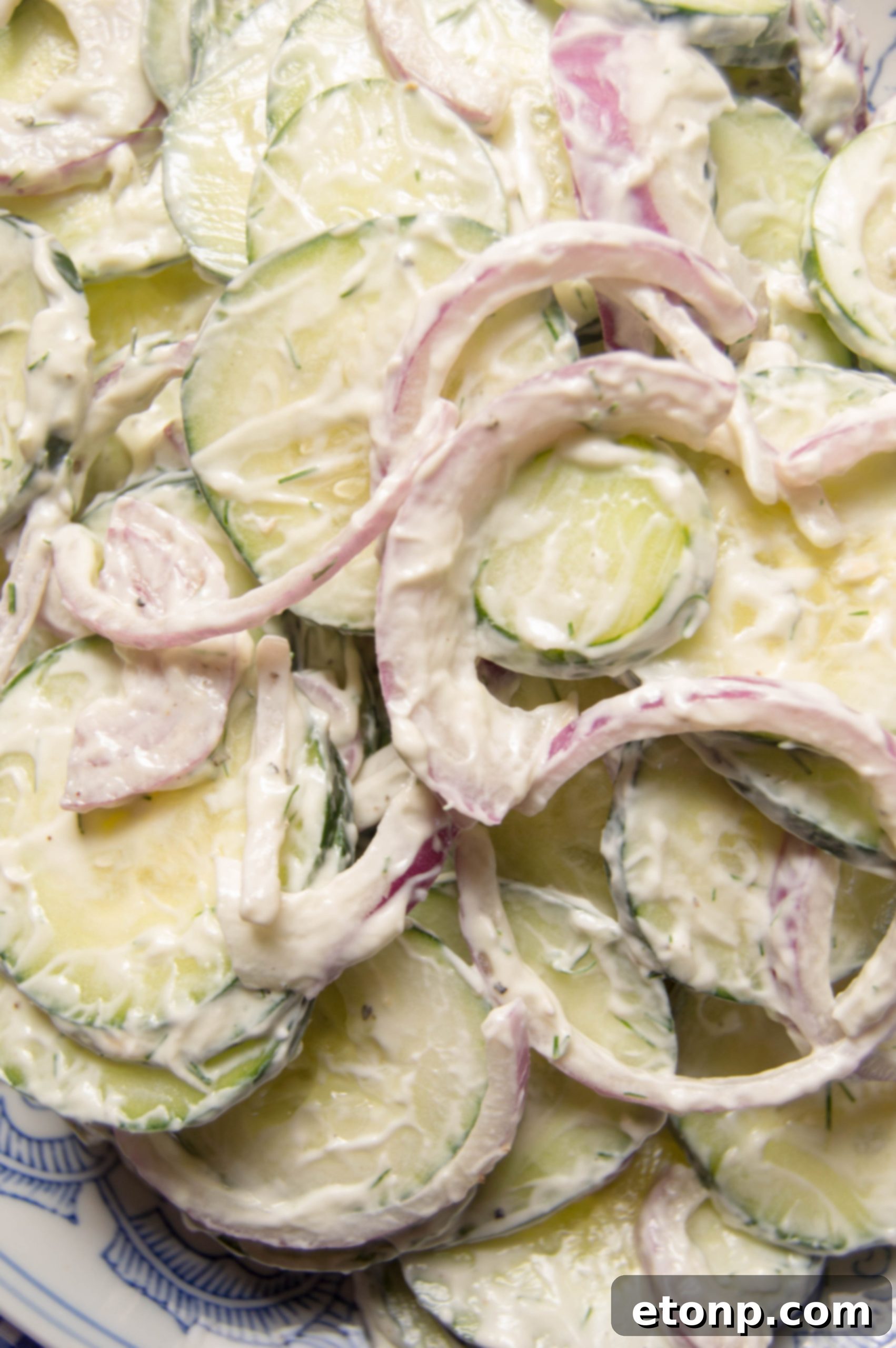 Small bowl of creamy cucumber salad being served
