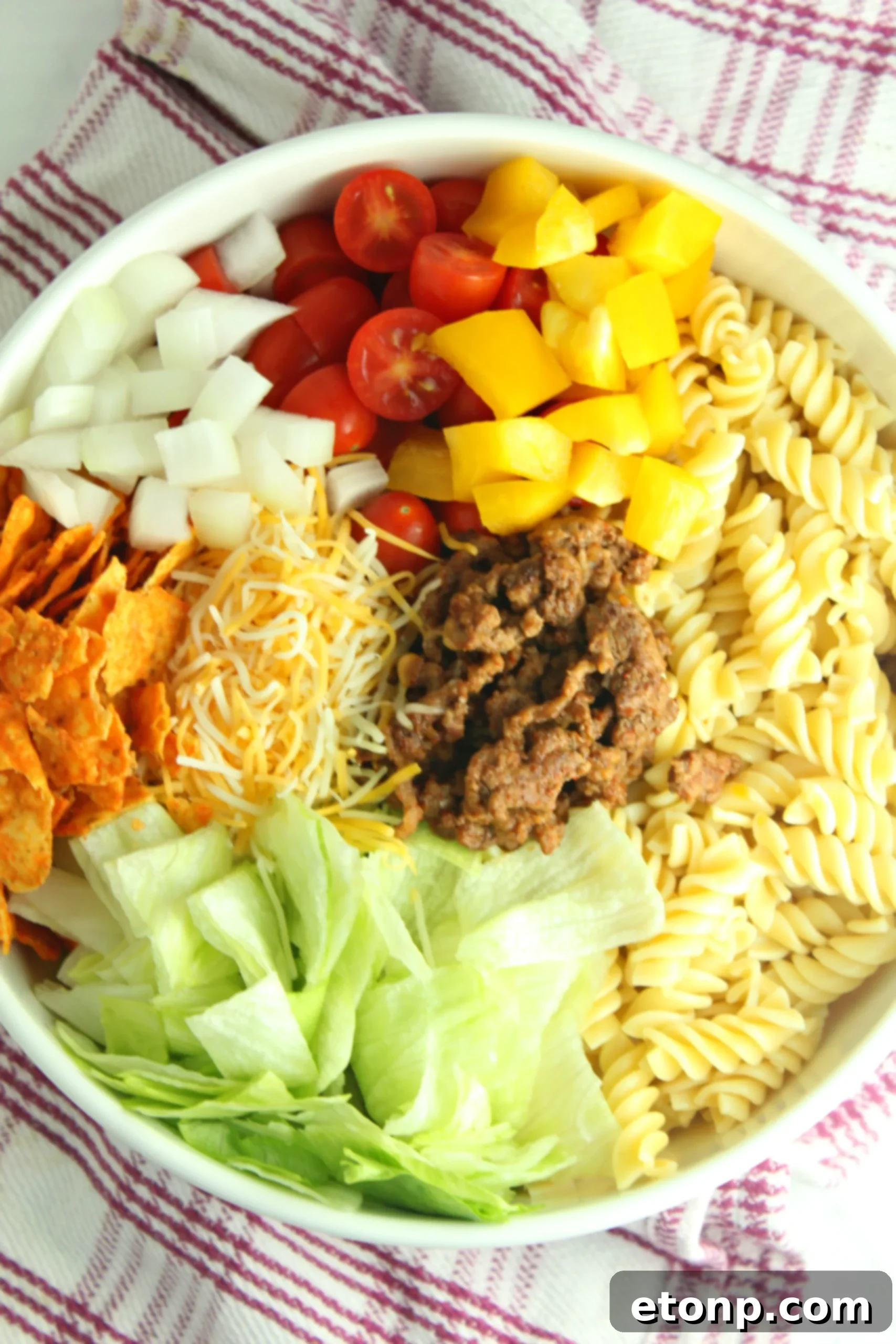 Close-up of the Doritos Locos Taco Pasta Salad, showcasing the ground beef, pasta, and colorful vegetables, ready to be enjoyed with salsa and sour cream.