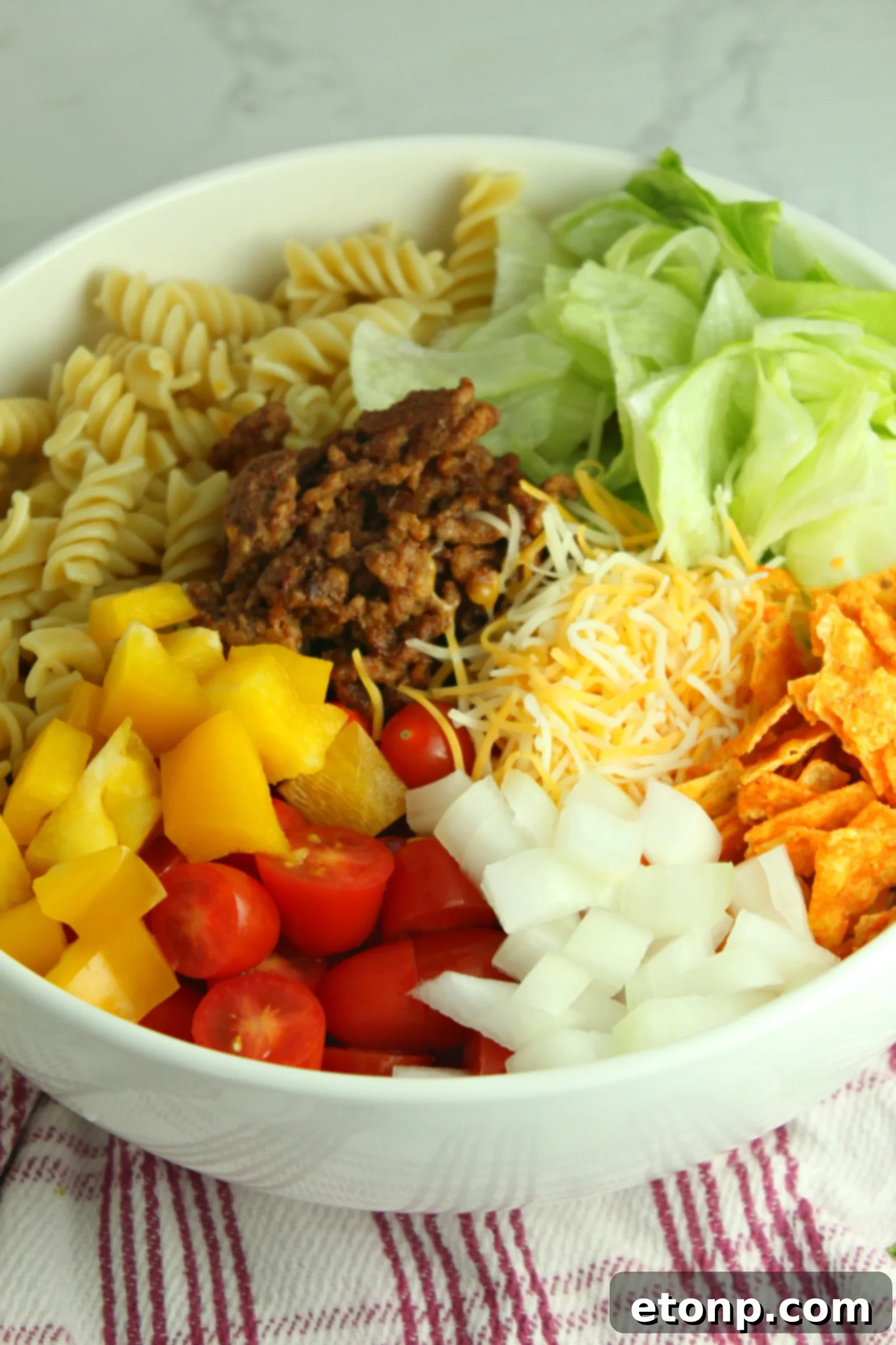 Ingredients for the Doritos Locos Taco Pasta Salad laid out, emphasizing the use of common, accessible items found in most kitchens.