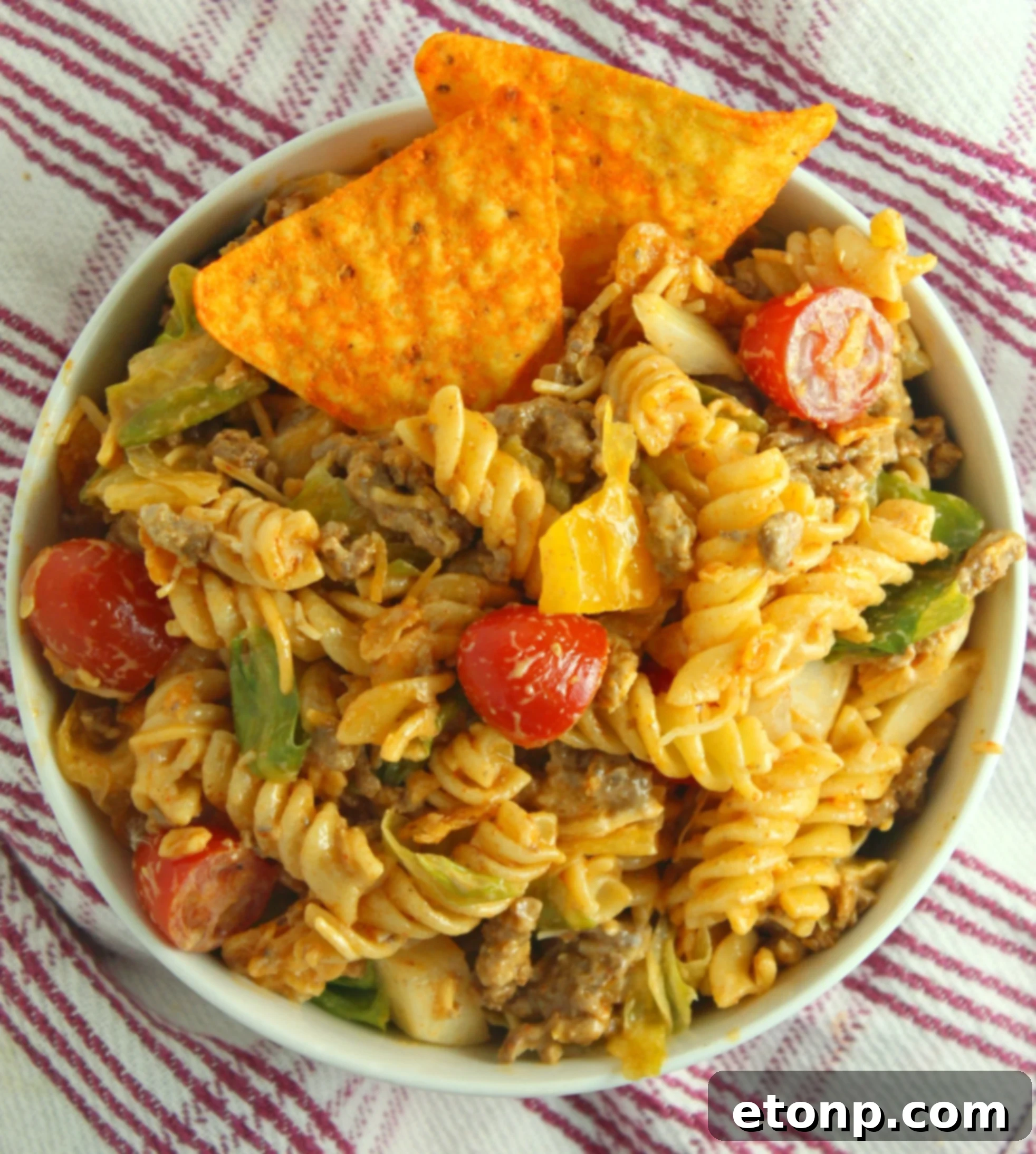 A spoonful of Doritos Locos Taco Pasta Salad, highlighting the ground beef and its protein contribution to the dish.